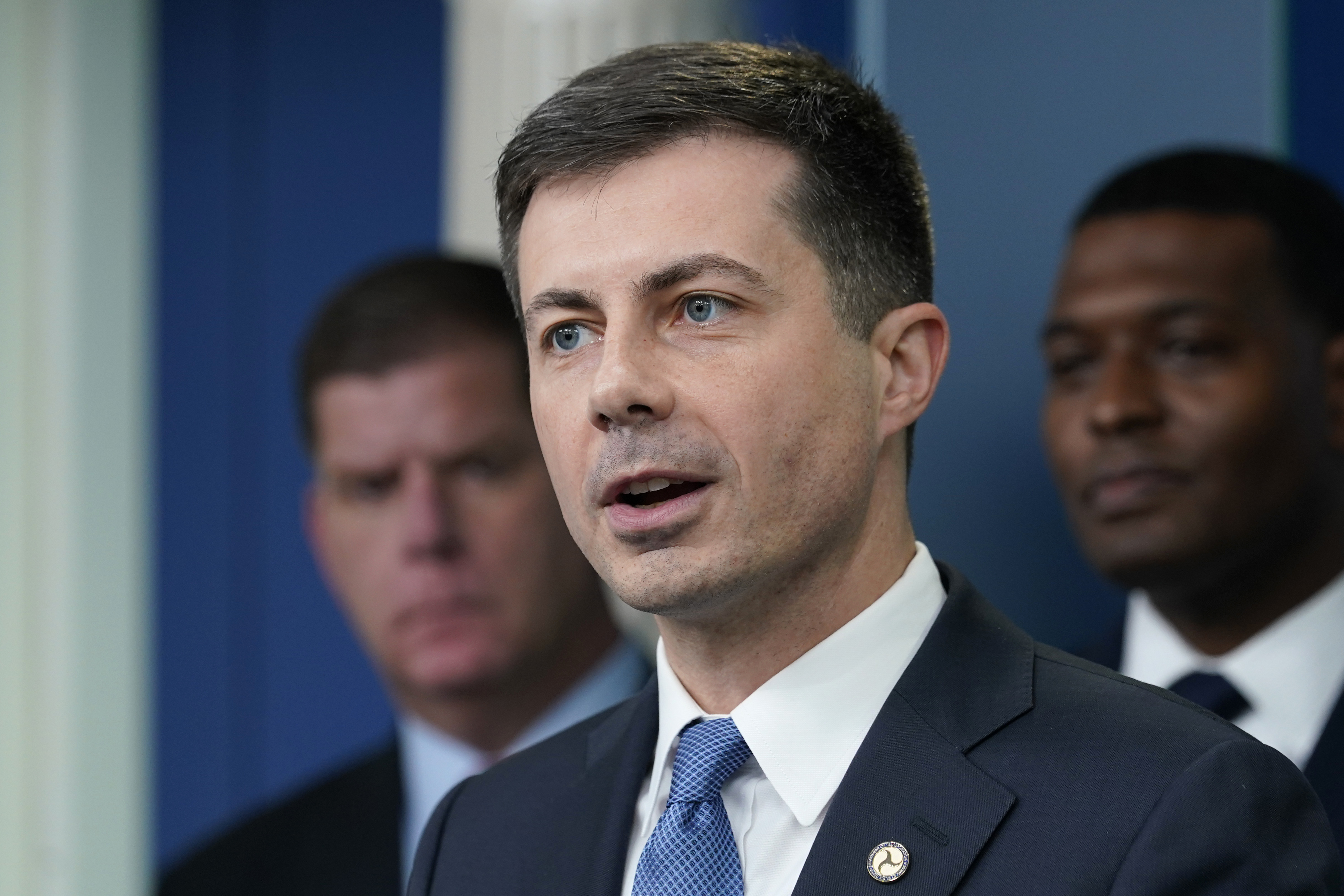 Transportation Secretary Pete Buttigieg, center, speaks during a briefing at the White House in Washington, May 16, as Labor Secretary Marty Walsh, left, and Environmental Protection Agency administrator Michael Regan, right, listen. The Biden administration is saying the U.S. economy would face a severe economic shock if senators don't pass legislation this week to avert a rail worker strike.