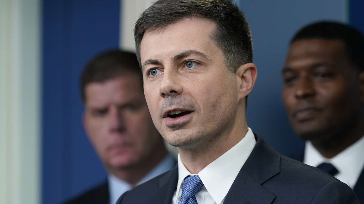 Transportation Secretary Pete Buttigieg, center, speaks during a briefing at the White House in Washington, May 16, as Labor Secretary Marty Walsh, left, and Environmental Protection Agency administrator Michael Regan, right, listen. The Biden administration is saying the U.S. economy would face a severe economic shock if senators don't pass legislation this week to avert a rail worker strike.