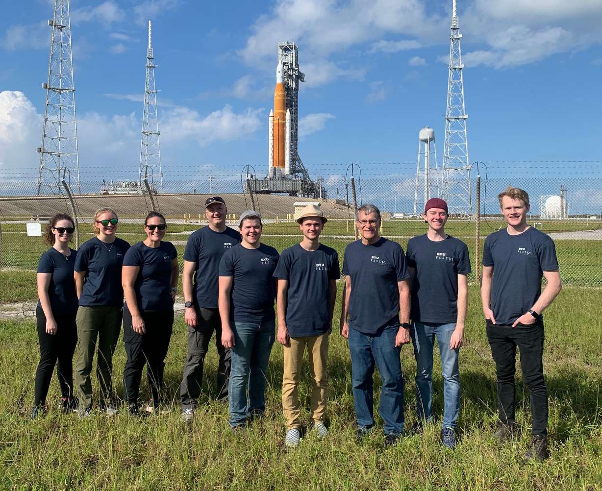 BYU researchers from the school’s Department of Physics and Astronomy pose for a photo at Kennedy Space Center with the Space Launch System/Orion crew capsule stack in the background. The team was there to capture audio recordings of the rocket launch from Cape Canaveral, Fla., on Nov. 16. From left to right: Maggie Kuffskie, Makayle Kellison, Dr. Whitney Coyle, Dr. Kent Gee, Michael Bassett, Levi Moats, Dr. Grant Hart, Carson Cunningham and Taggart Durrant.