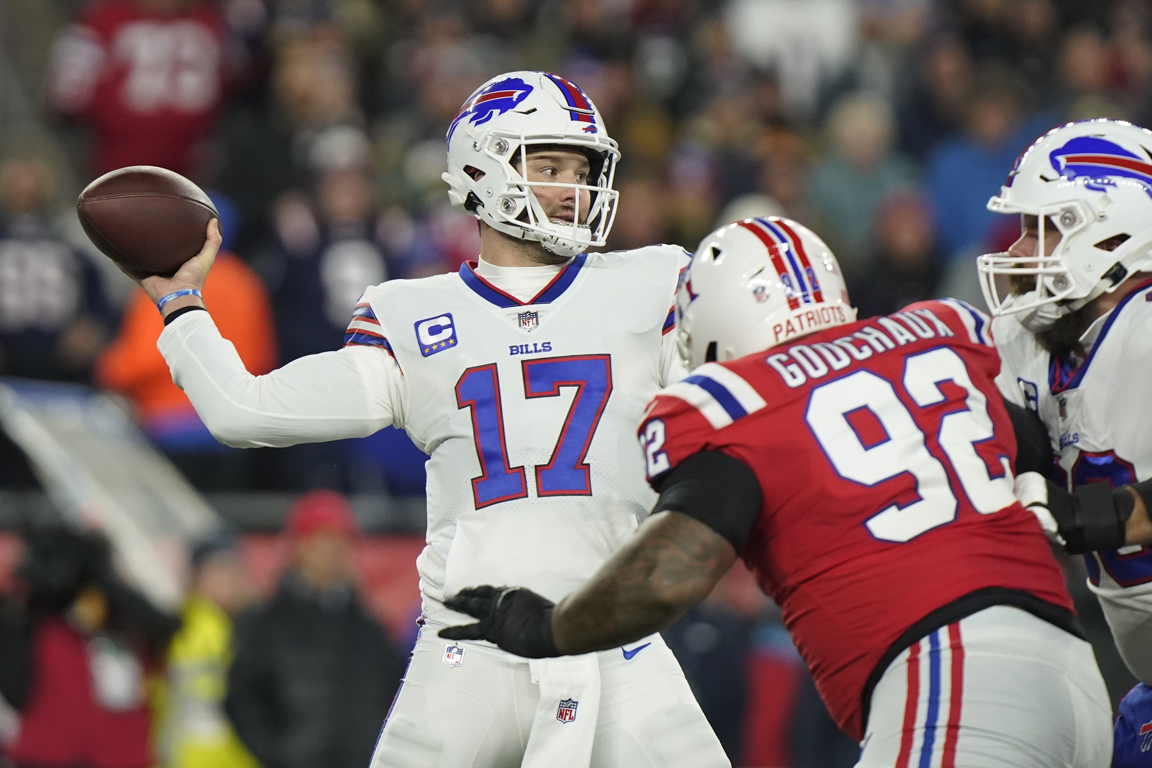 Buffalo Bills quarterback Josh Allen (17) throws under pressure from New England Patriots defensive tackle Davon Godchaux (92) during the first half of an NFL football game, Thursday, Dec. 1, 2022, in Foxborough, Mass. 