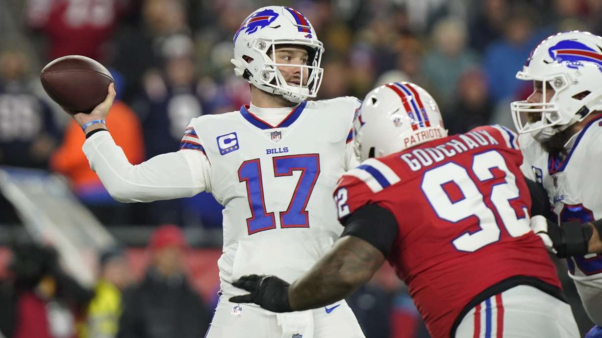 Buffalo Bills quarterback Josh Allen (17) throws under pressure from New England Patriots defensive tackle Davon Godchaux (92) during the first half of an NFL football game, Thursday, Dec. 1, 2022, in Foxborough, Mass.
