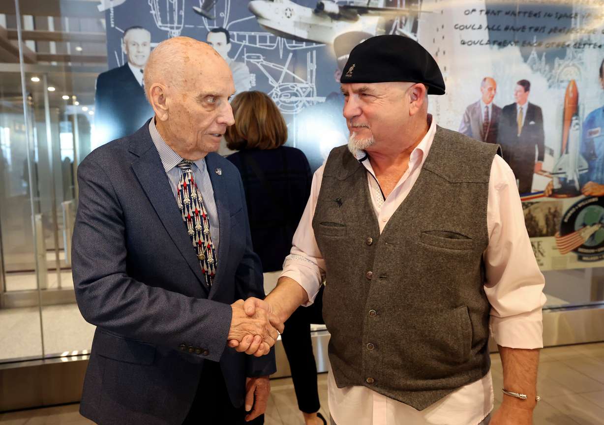 Retired U.S. Sen. Jake Garn, who is also Utah’s first astronaut, shakes hands with artist Gordon Huether, during an unveiling ceremony for an art installation made by Huether honoring Garn, at the Salt Lake City International Airport greeting room in Salt Lake City on Saturday.