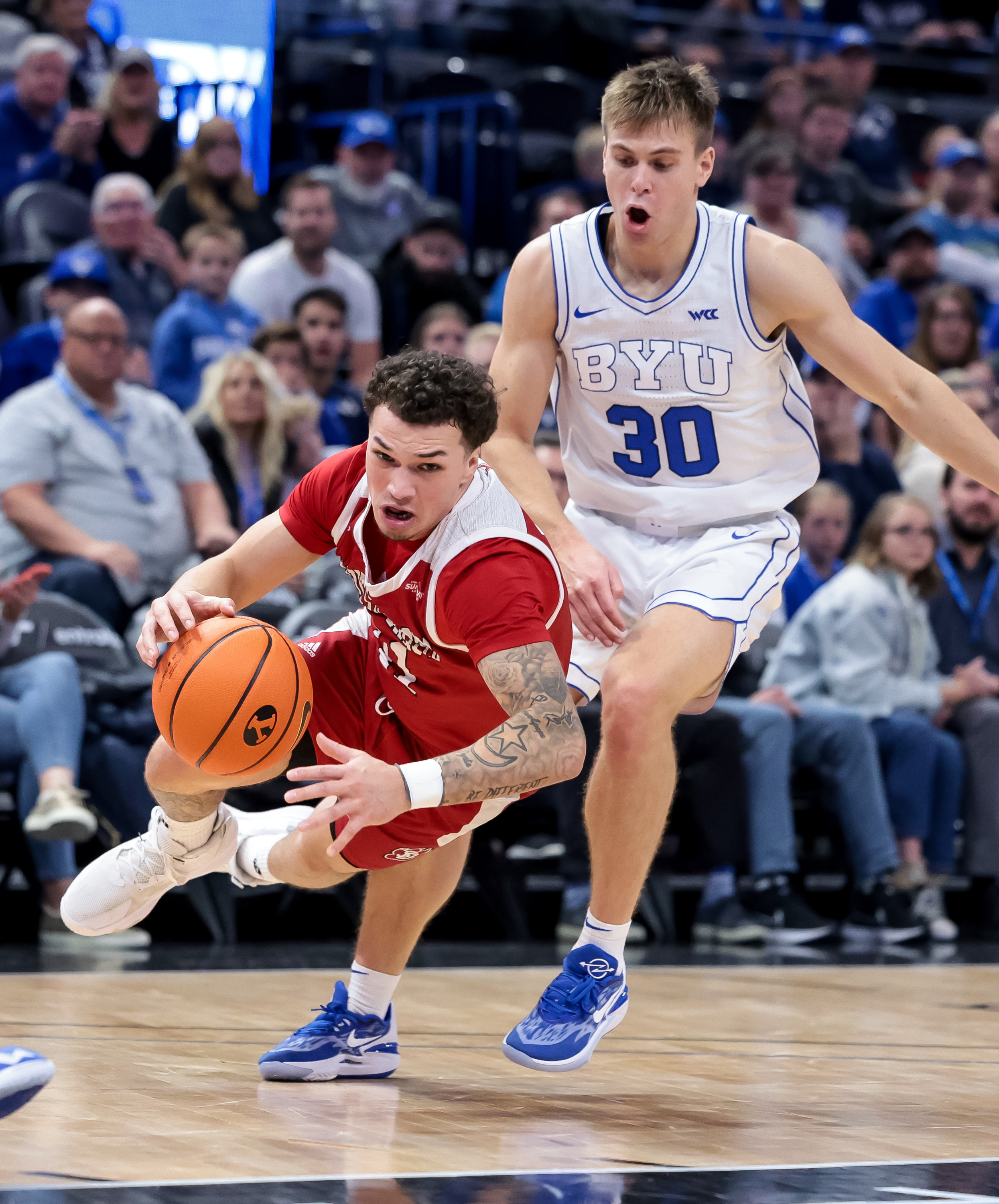 BYU Cougars guard Dallin Hall (30) is charged with a foul as South Dakota Coyotes guard Mason Archambault (11) hits the boards in the final moments of the game at Vivint Arena in Salt Lake City on Saturday, Dec. 3, 2022.