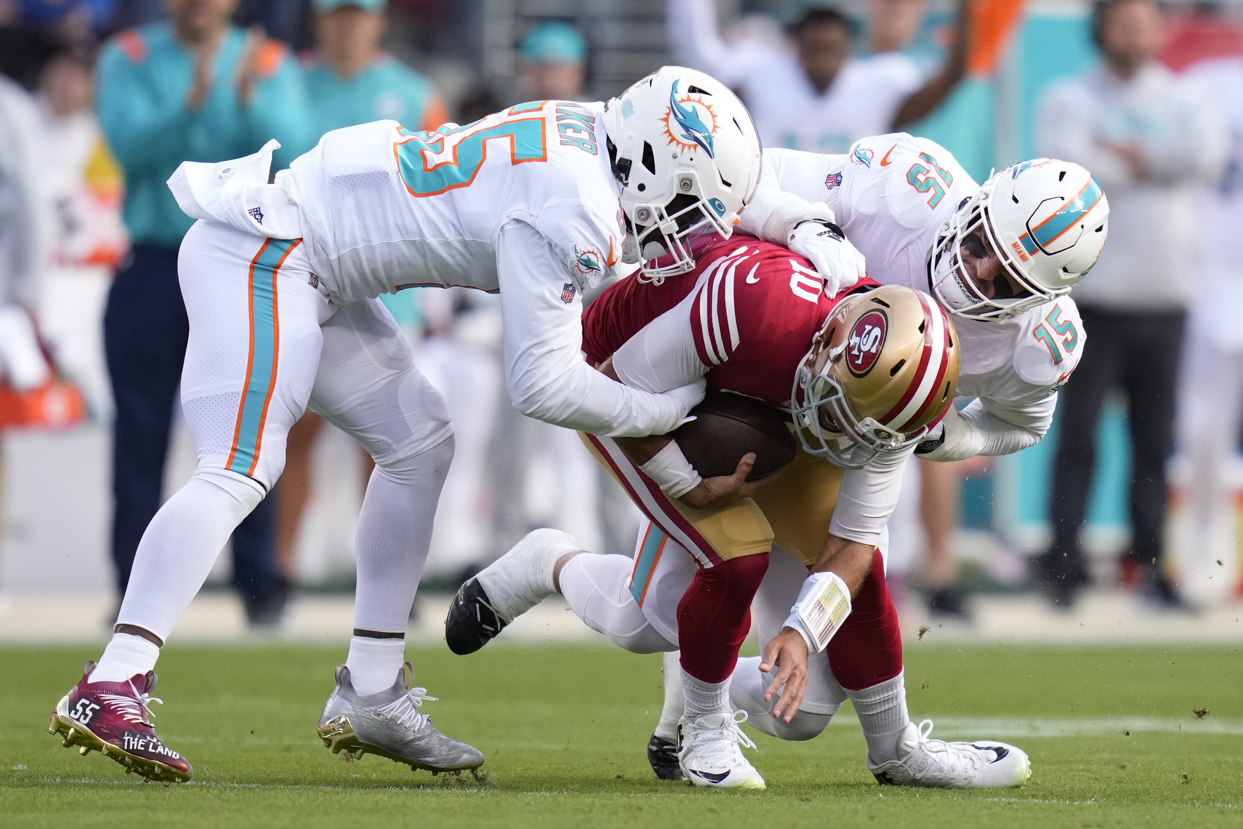 San Francisco 49ers quarterback Jimmy Garoppolo, middle, is sacked by Miami Dolphins linebacker Jerome Baker, left, and linebacker Jaelan Phillips (15) during the first half of an NFL football game in Santa Clara, Calif., Sunday, Dec. 4, 2022. 