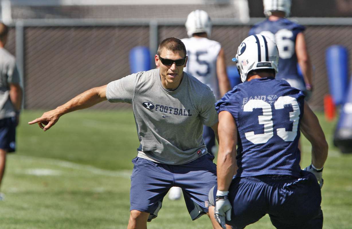 Linebackers coach Kelly Poppinga runs drills with Bryan Kariya during BYU football practice Monday, Aug. 8, 2011, in Provo, Utah.