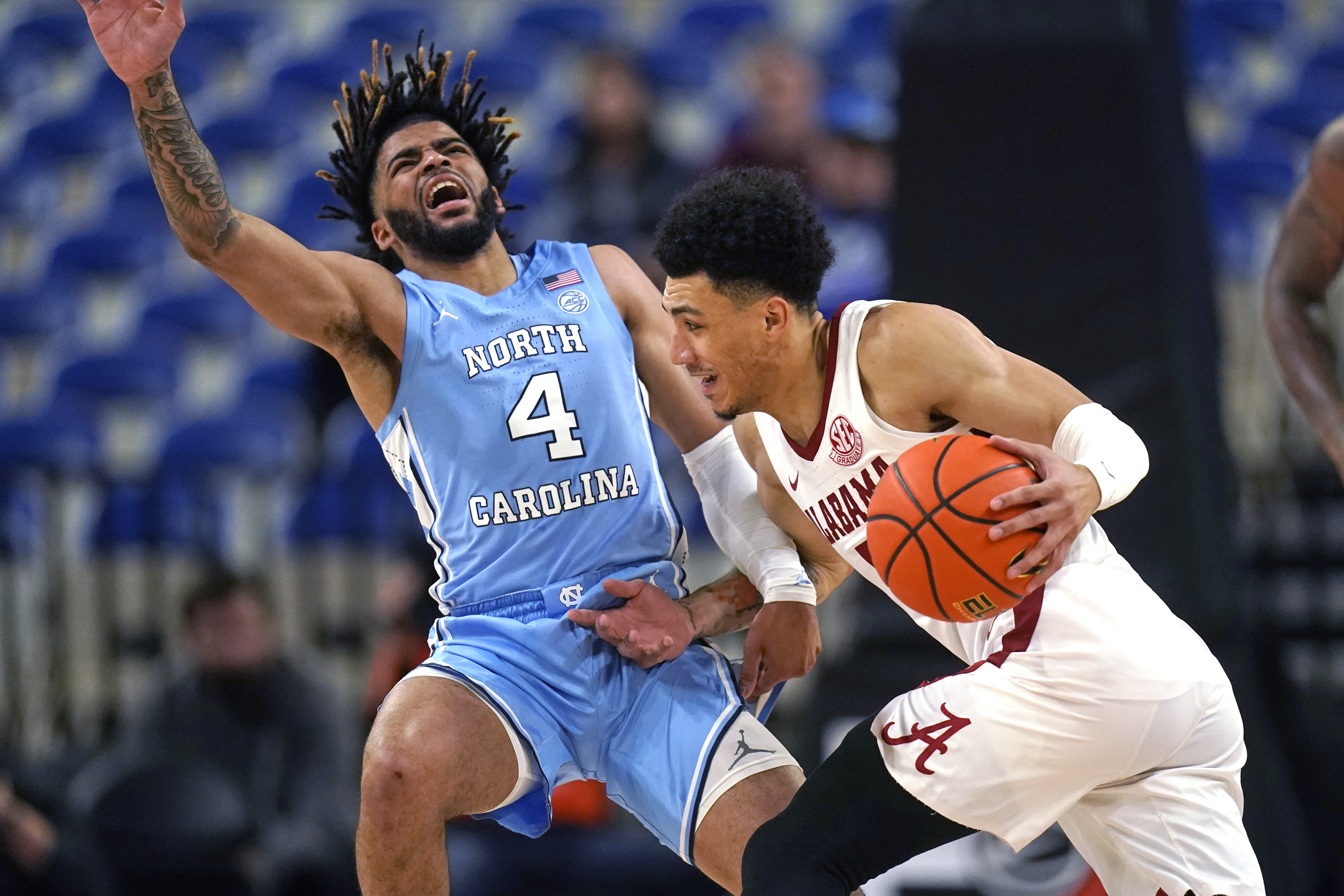 North Carolina guard R.J. Davis (4) fouls Alabama guard Jahvon Quinerly during the first half of an NCAA college basketball game in the Phil Knight Invitational on Sunday, Nov. 27, 2022, in Portland, Ore. 