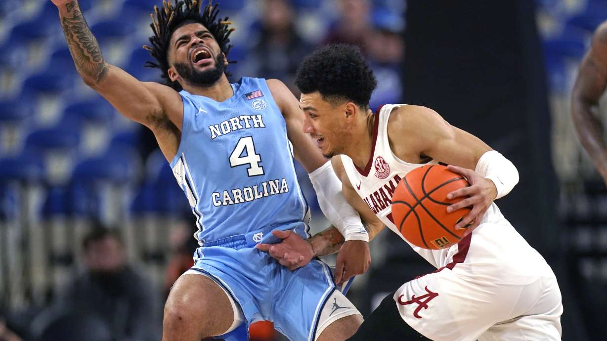 North Carolina guard R.J. Davis (4) fouls Alabama guard Jahvon Quinerly during the first half of an NCAA college basketball game in the Phil Knight Invitational on Sunday, Nov. 27, 2022, in Portland, Ore.