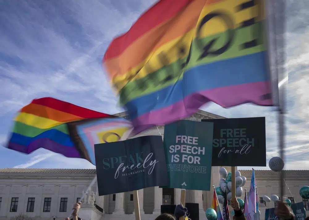 People on both sides of the debate rally outside the Supreme Court in Washington, Monday. The Supreme Court is hearing the case of a Christian graphic artist, who objects to designing wedding websites for gay couples, that's the latest clash of religion and gay rights to land at the highest court.