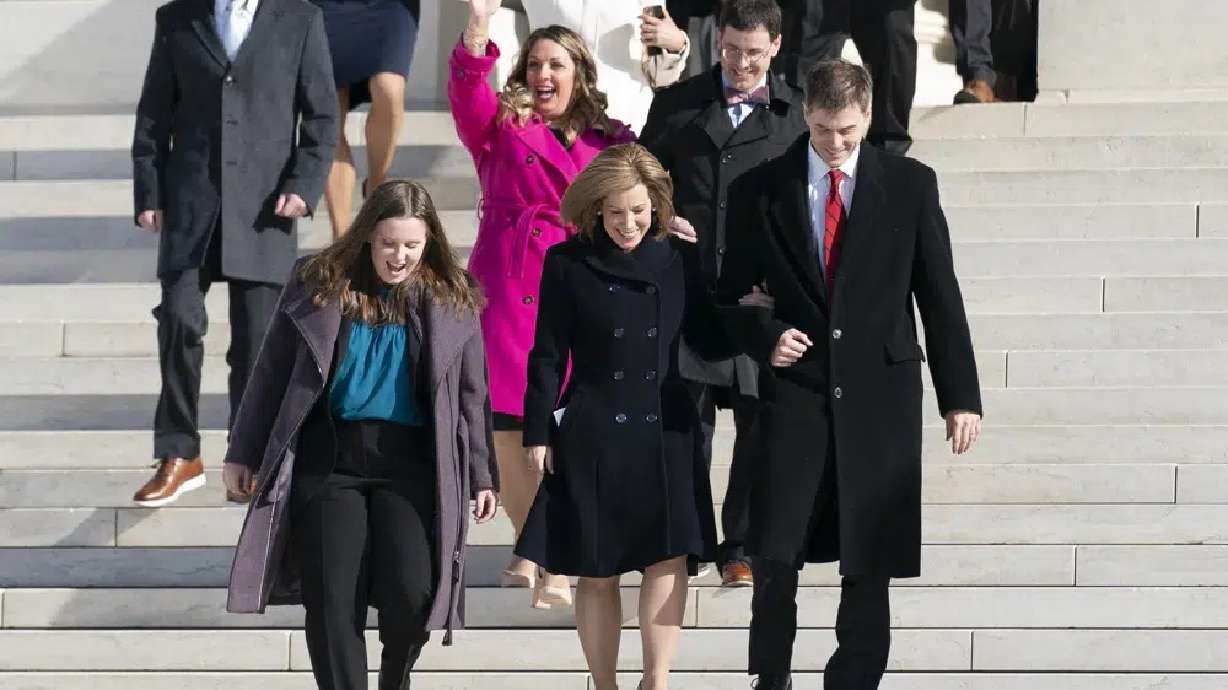 Lorie Smith, a Christian graphic artist and website designer in Colorado, center in pink, walks out of the Supreme Court in Washington, Monday, after her case was heard before the Supreme Court. The Supreme Court is hearing the case of Smith, who objects to designing wedding websites for gay couples, that's the latest clash of religion and gay rights to land at the highest court.