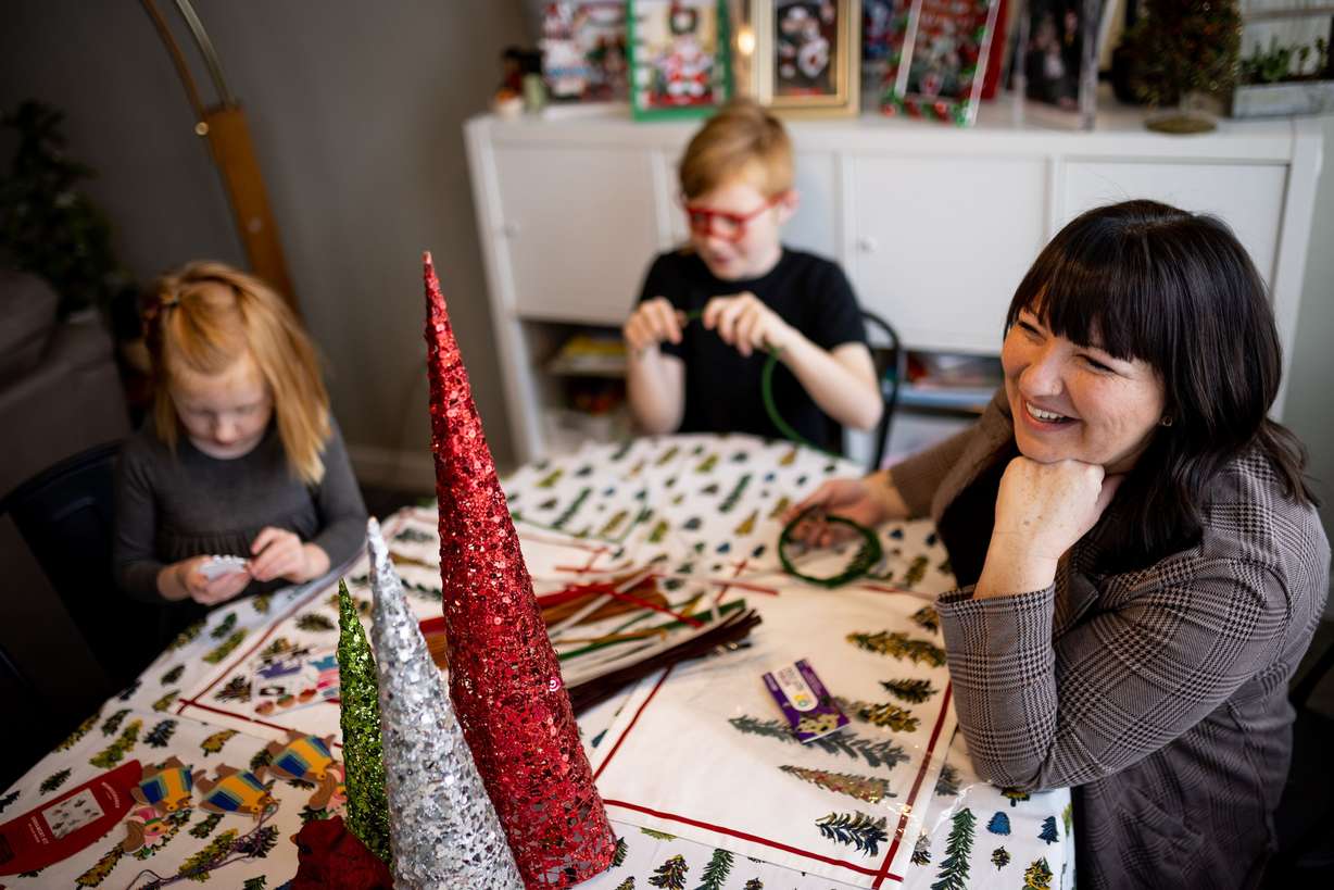 Betsy Ryan does a holiday craft project with her children Mara, 5, left, Benjamin, 10, center, and Teddy, 6, not pictured, at their home in Centerville on Saturday.