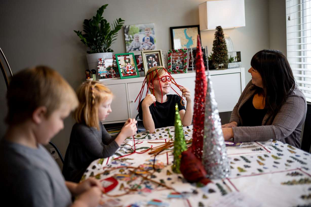 Betsy Ryan does a holiday craft project with her children Teddy, 6, left, Mara, 5, and Benjamin, 10, at their home in Centerville on Saturday.