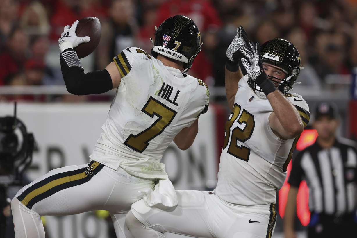 New Orleans Saints Taysom Hill (7) celebrates his touchdown reception with tight end Adam Trautman (82) in the first half of an NFL football game in Tampa, Fla., Monday, Dec. 5, 2022.