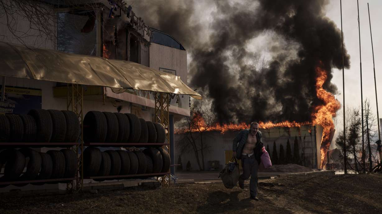 A man recovers items from a burning shop following a Russian attack in Kharkiv, Ukraine, on March 25.