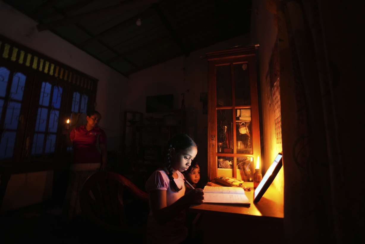 A girl uses a kerosine oil lamp to attend online lessons during a power cut brought on by a fuel shortage in Colombo, Sri Lanka, on March 4.