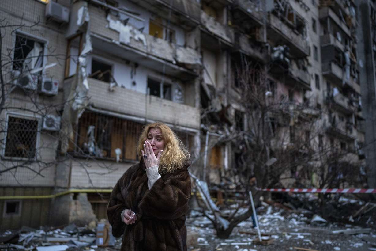 Natali Sevriukova cries in front of the building that was her home following a rocket attack in Kyiv, Ukraine, on Feb. 25.