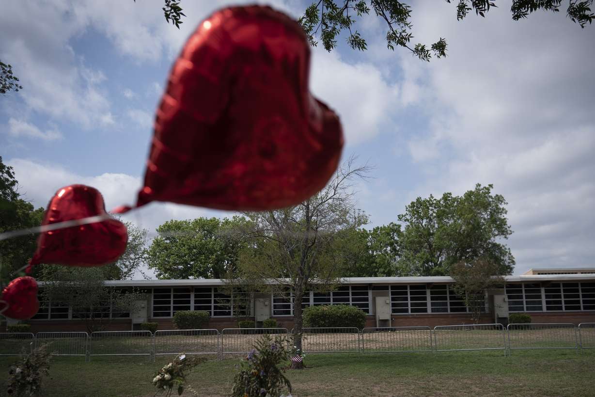 A heart-shaped balloon flies decorating a memorial site outside Robb Elementary School in Uvalde, Texas, Monday, May 30. Nineteen children and two teachers were killed by an 18-year-old gunman at the school last week.