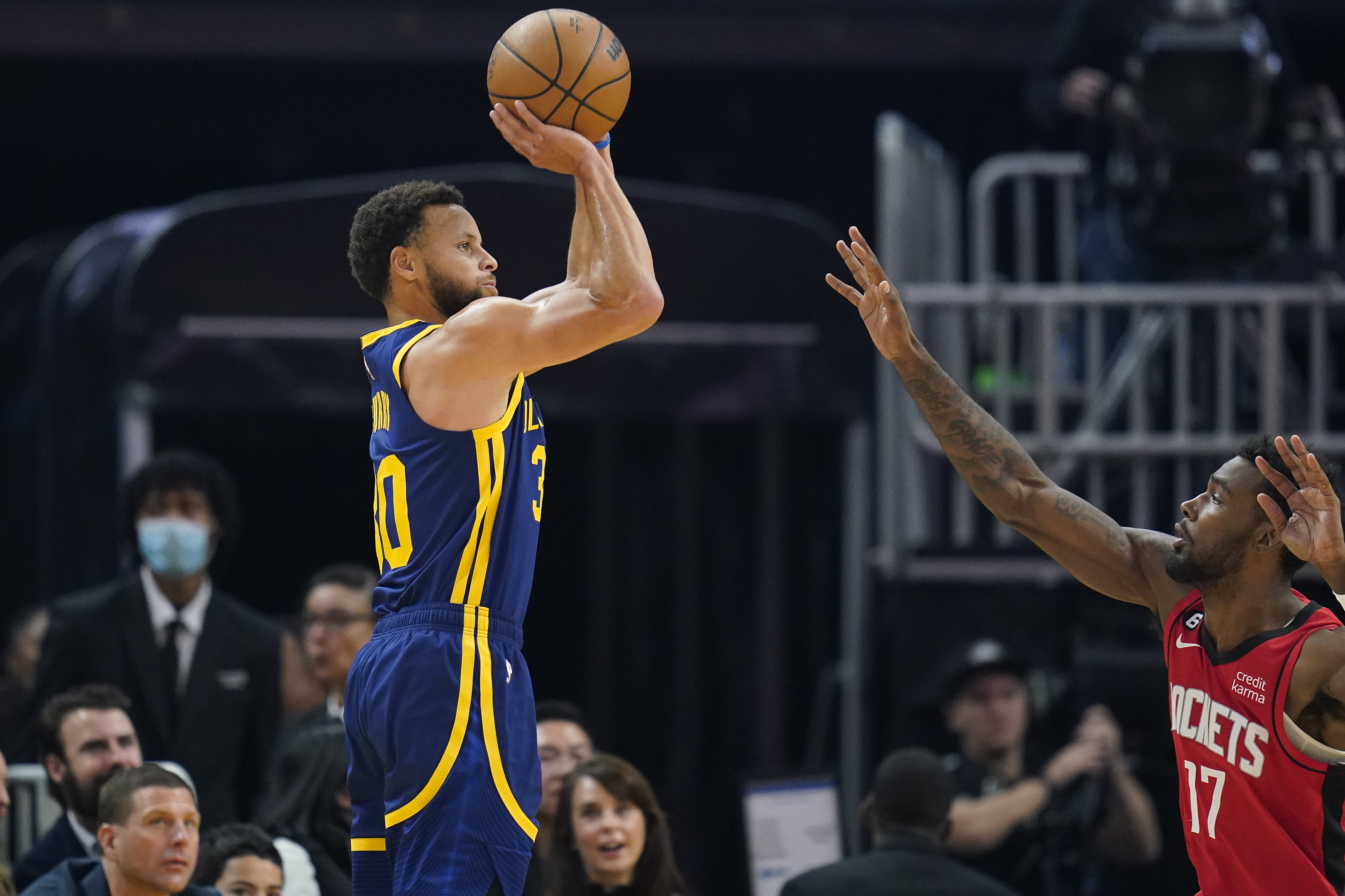 Golden State Warriors guard Stephen Curry, left, shoots a 3-point basket over Houston Rockets forward Tari Eason (17) during the first half of an NBA basketball game in San Francisco, Saturday, Dec. 3, 2022. 
