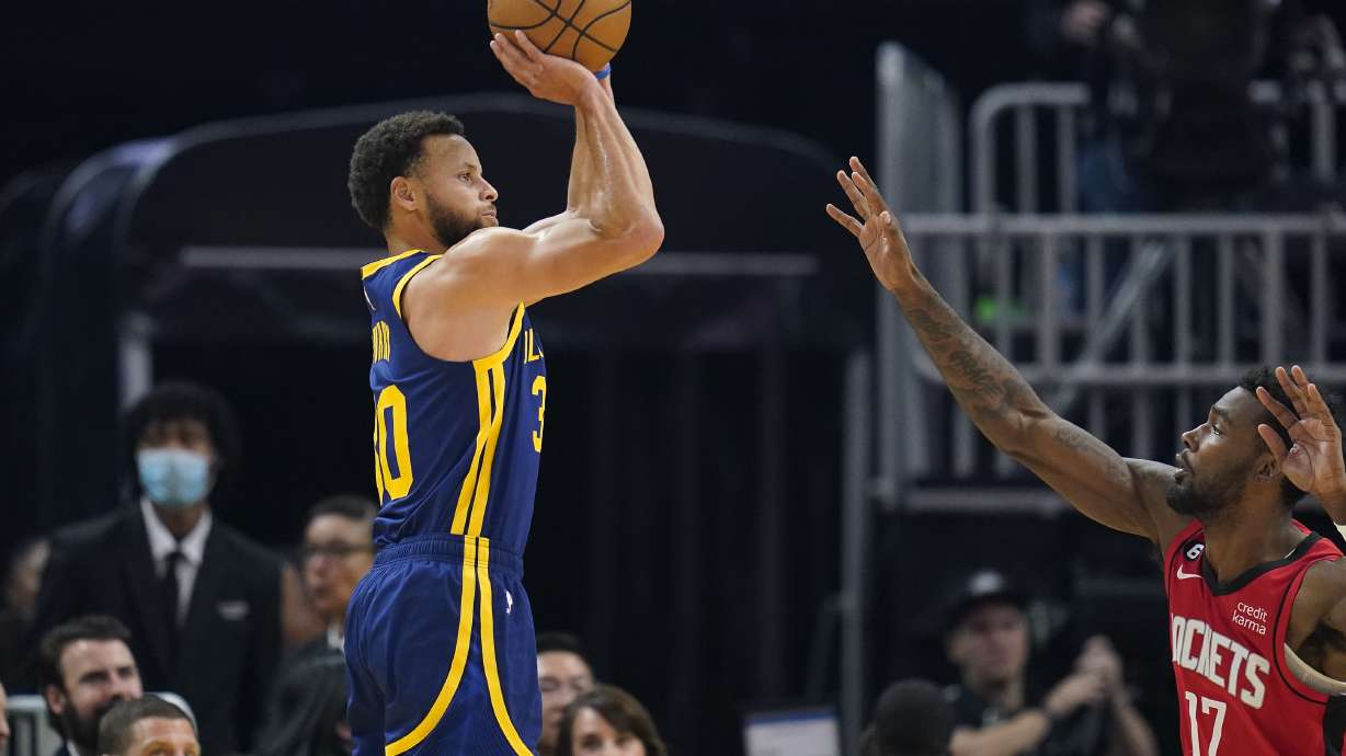 Golden State Warriors guard Stephen Curry, left, shoots a 3-point basket over Houston Rockets forward Tari Eason (17) during the first half of an NBA basketball game in San Francisco, Saturday, Dec. 3, 2022.