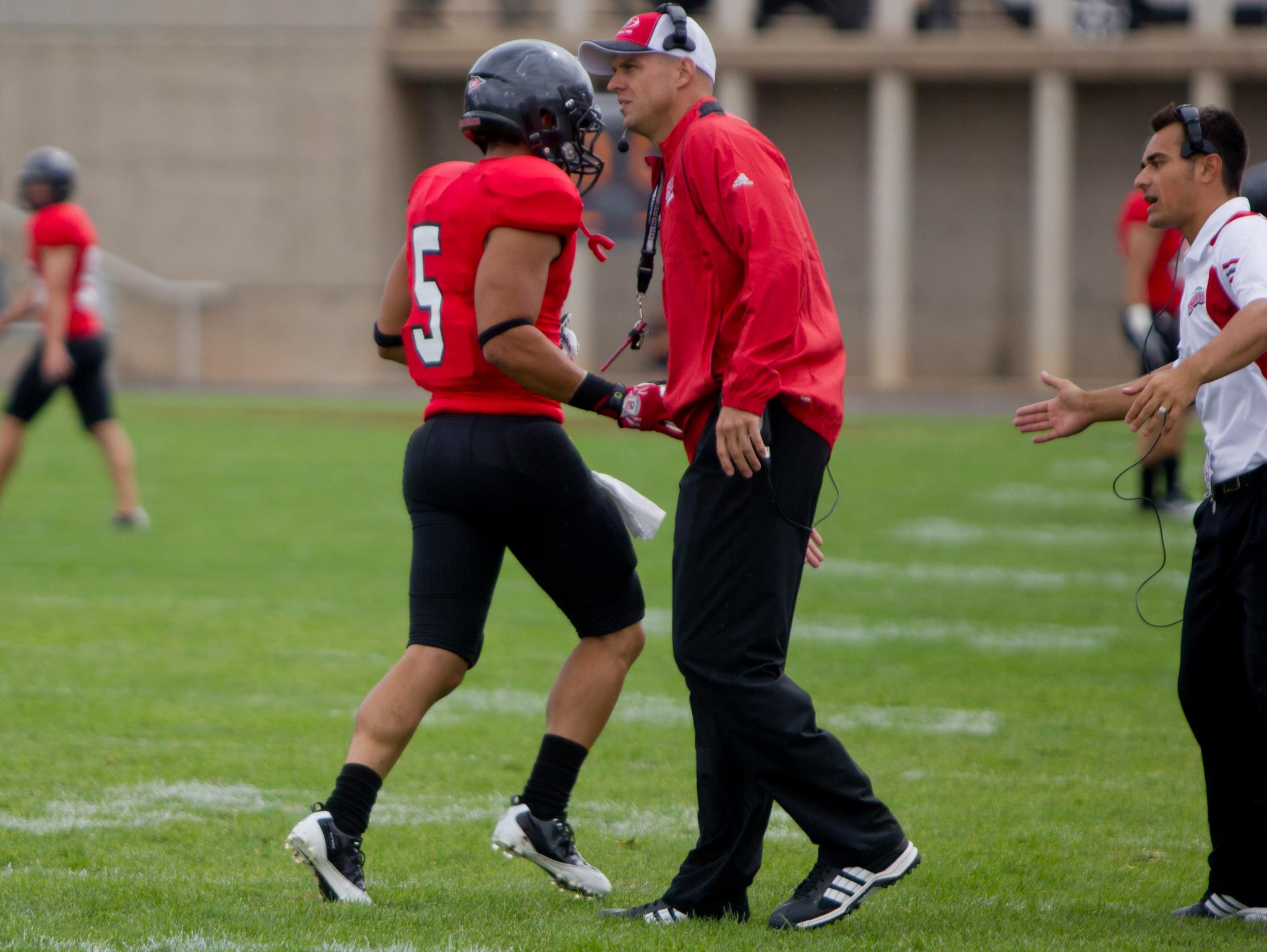 Southern Utah coach Ed Lamb shakes hands with wide receiver Jared Ursua (5) after a play during a game in Cedar City, Utah in 2011.