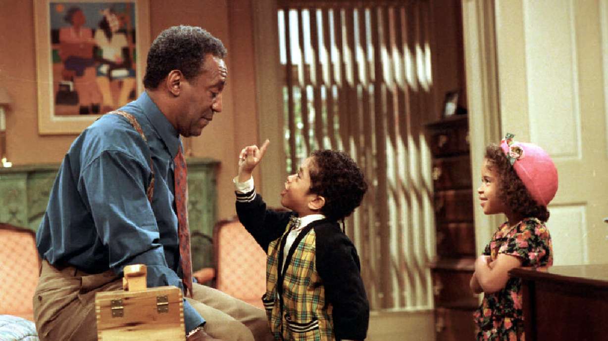 Bill Cosby, as Dr. Cliff Huxtable of "The Cosby Show," listens to a point made by his grandson Gary Gray, as his granddaughter played by Jessica Vaughn looks on during taping of the final episode before a live studio audience in New York City on March 6, 1992. Five women who have long accused Cosby of sexually assaulting them early in their careers have filed the latest lawsuit against the 85-year-old comedian — and this one calls NBCUniversal, a studio and a production company complicit in the abuse.
