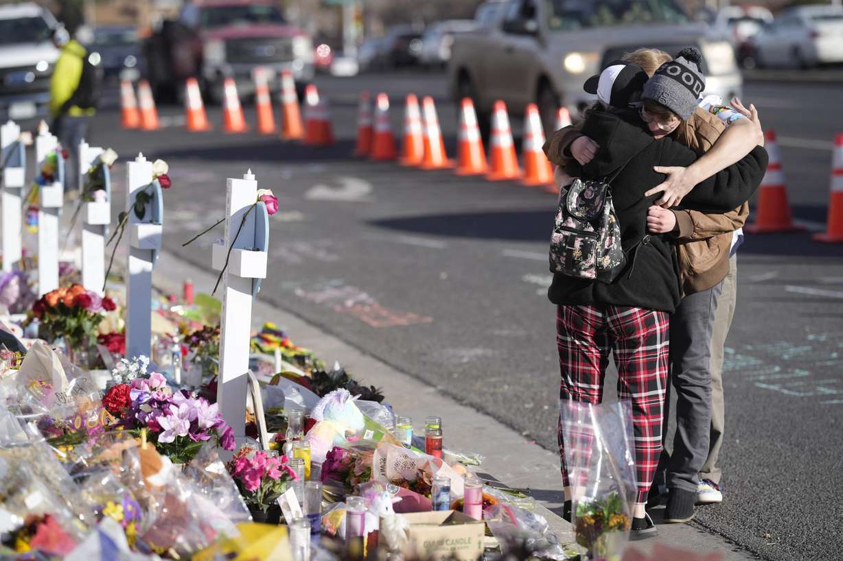 Visitors hug while looking over a makeshift memorial near the scene of a mass shooting at a gay nightclub Nov. 23 in Colorado Springs, Colo. The alleged shooter facing possible hate crime charges in the fatal shooting of five people at a Colorado Springs gay nightclub is scheduled to make their first court appearance Wednesday from jail after being released from the hospital a day earlier.