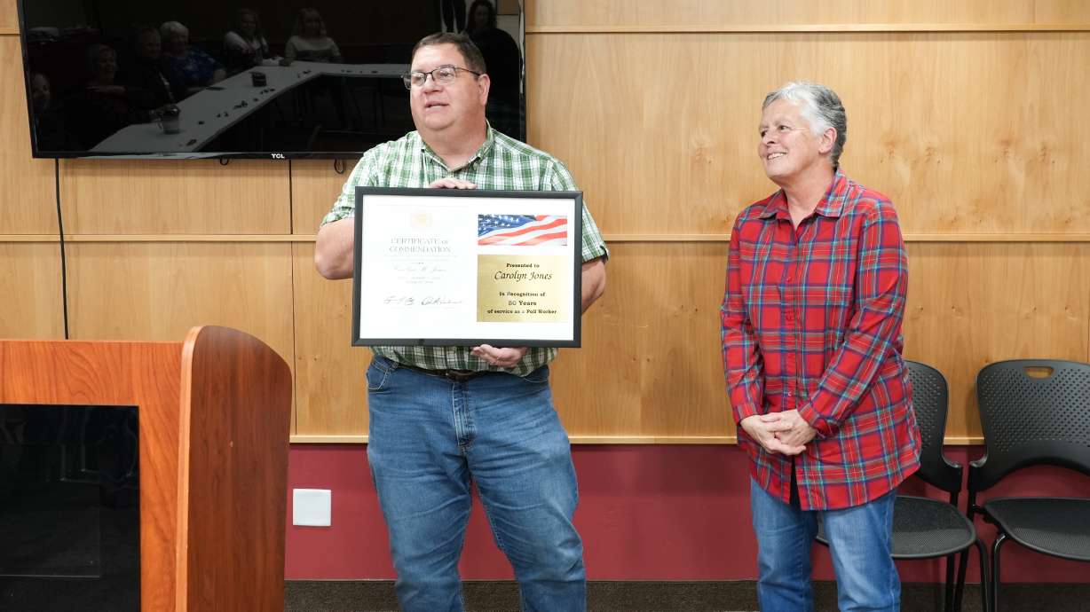 Iron County Clerk Jon Whittaker presents poll worker Carolyn Jones with a plaque to honor her 50 years of service.