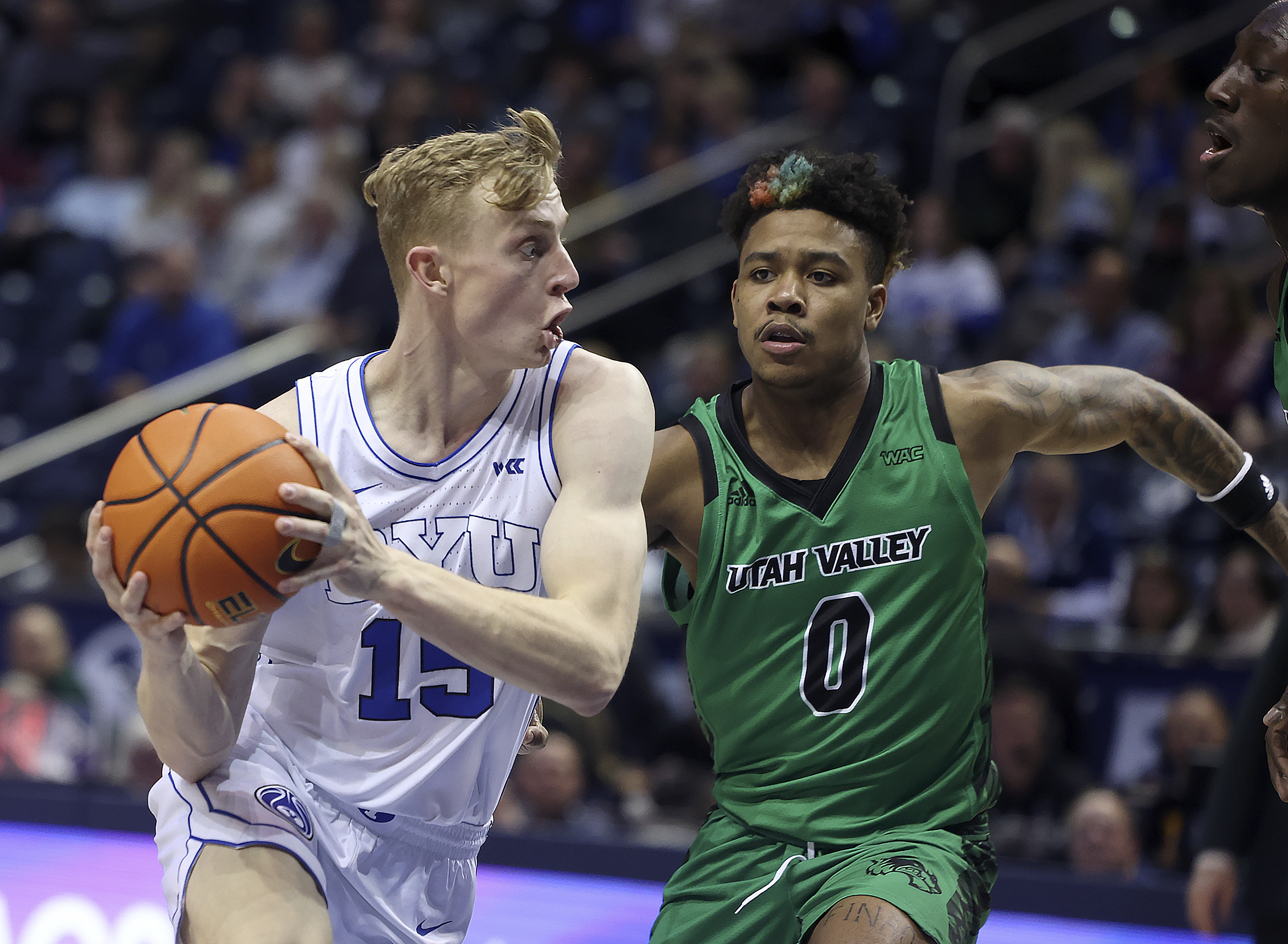 Brigham Young guard Richie Saunders (15) drives past Utah Valley guard Justin Harmon (0) at BYU in Provo on Wednesday, Dec. 7,  2022.