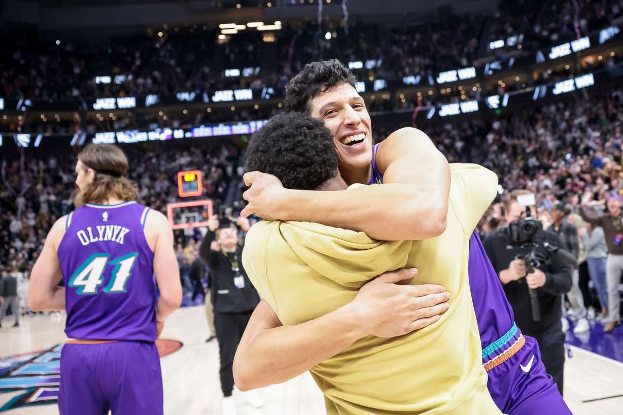 Utah Jazz guard Mike Conley (11) hugs forward Simone Fontecchio (16) after Fontecchio hit the game-winning dunk to give the Jazz a 124-123 win over the Golden State Warriors at Vivint Arena in Salt Lake City on Wednesday, Dec. 7, 2022.
