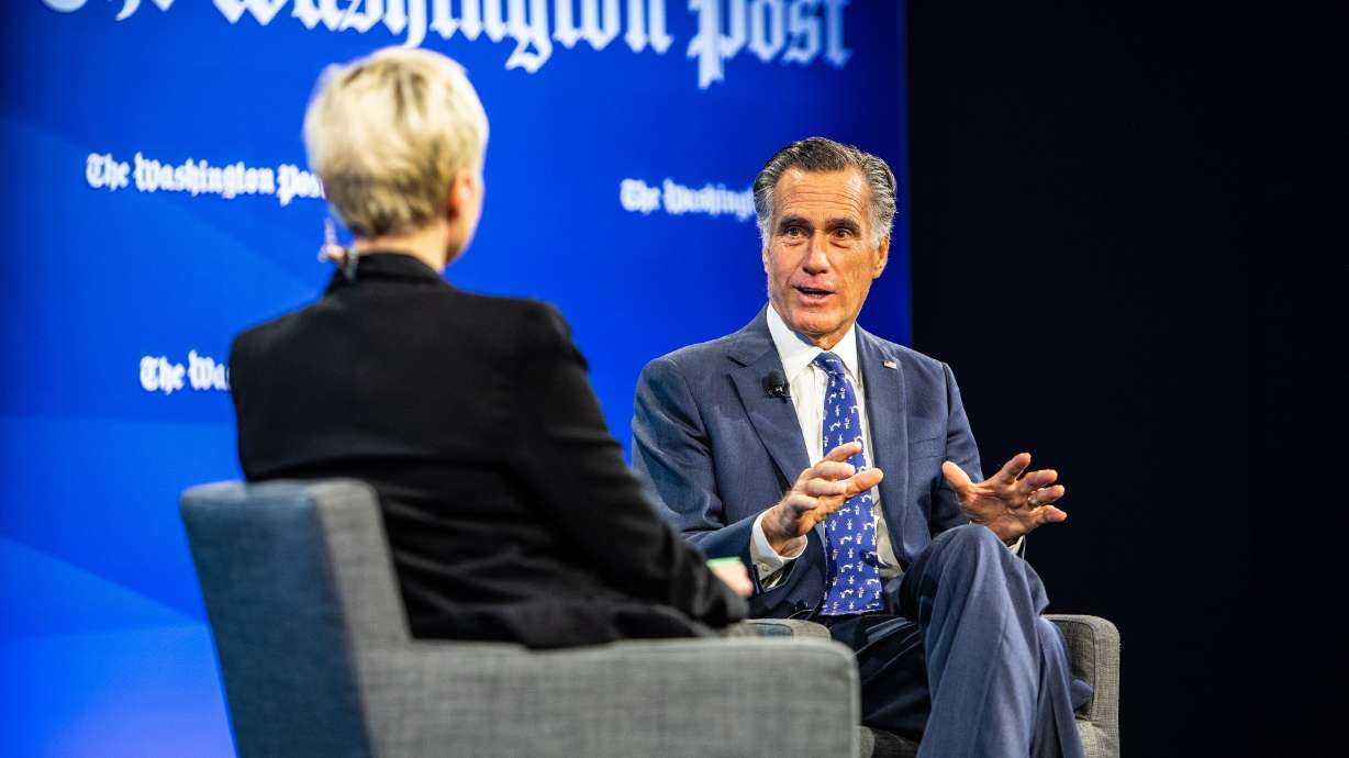 Sen. Mitt Romney, R-Utah, talks to Washington Post political reporter Leigh Ann Caldwell, left, during a Washington Post discussion on climate change on Thursday.