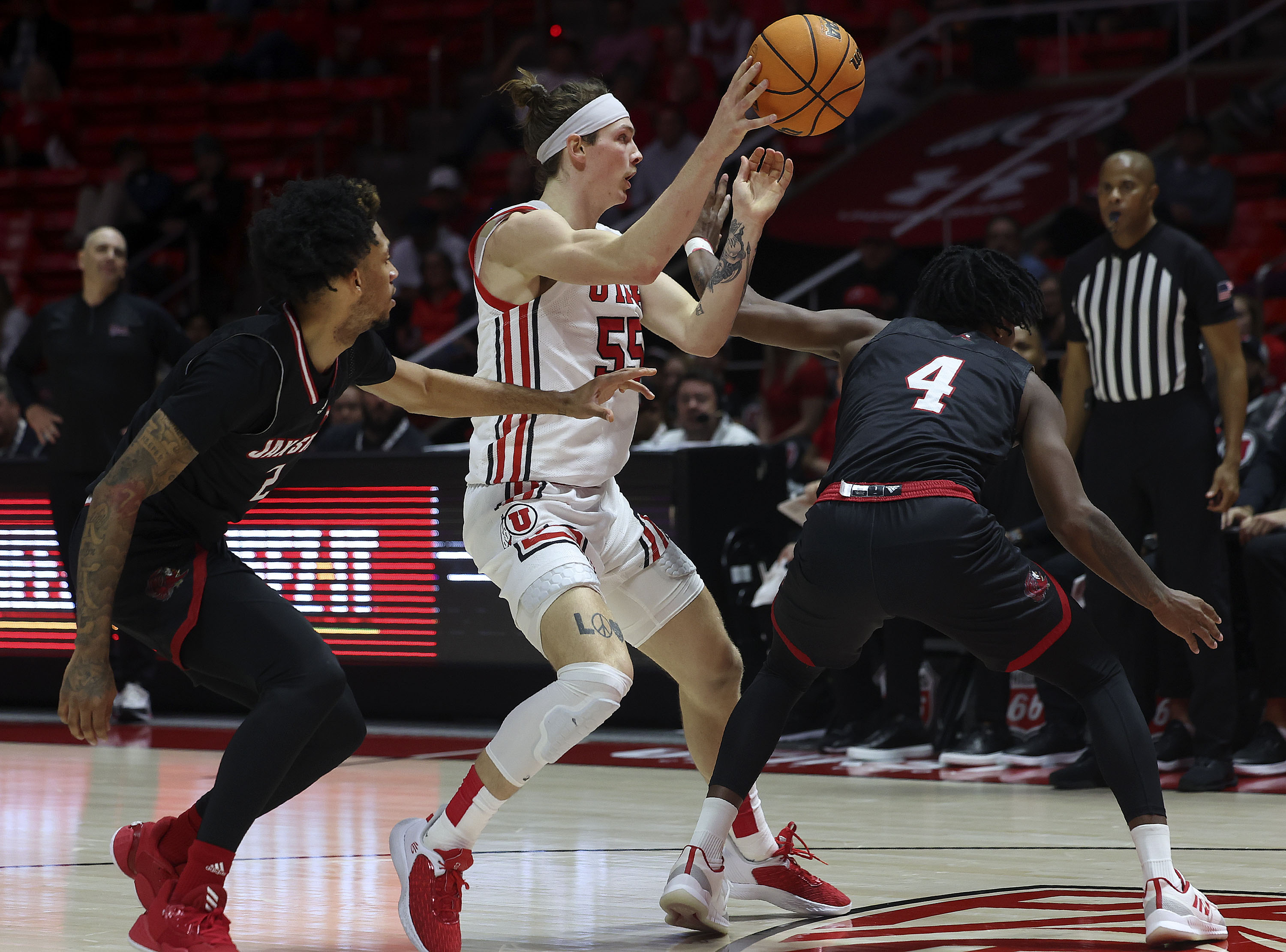Utah Utes guard Gabe Madsen (55) passes the ball as Jacksonville State Gamecocks guard Cam McDowell (2) and forward Marcellus Brigham Jr. (4) defend him at the Jon M. Huntsman Center in Salt Lake City on Thursday, Dec. 8, 2022.