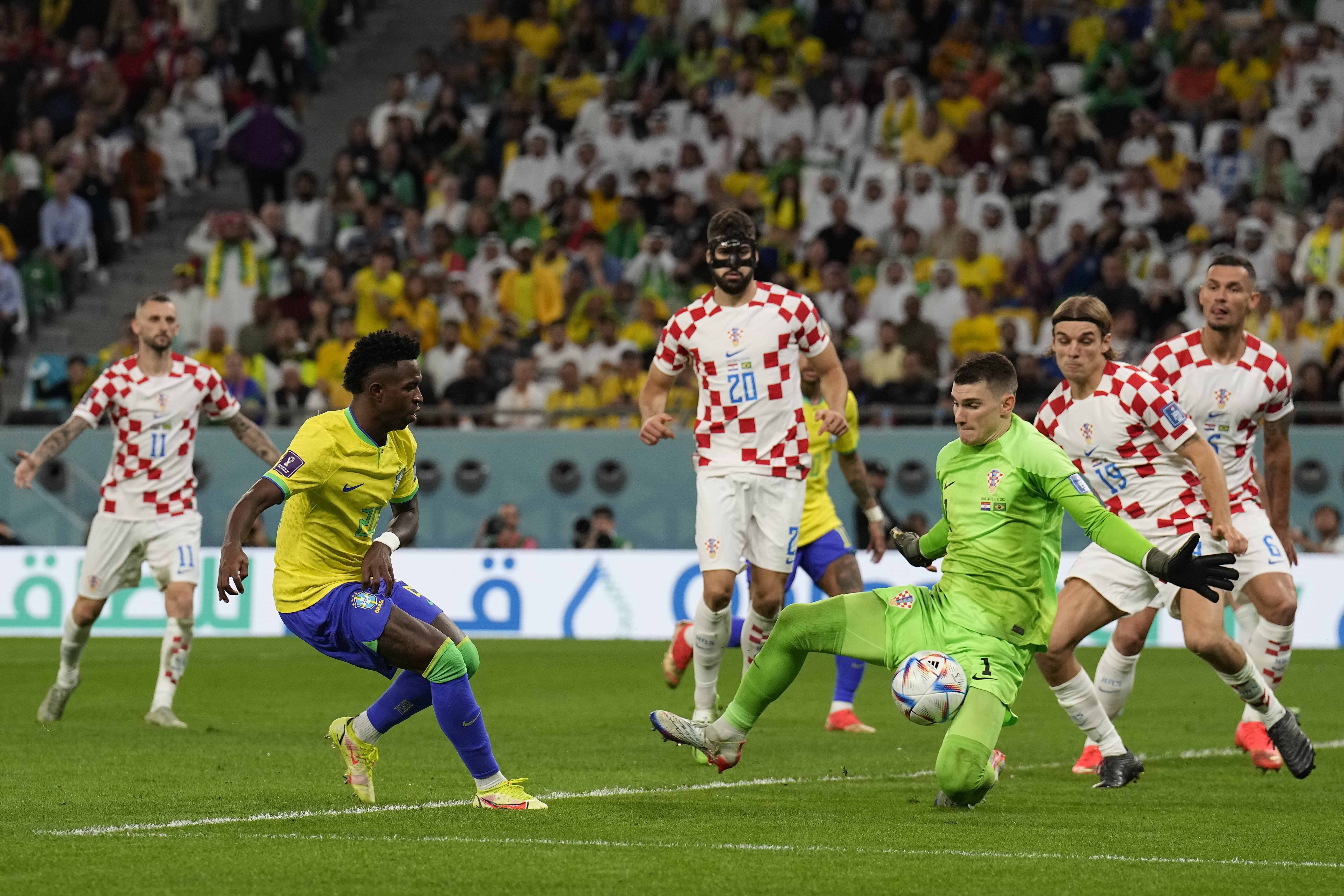Brazil's Vinicius Junior, left, tries to score past Croatia's goalkeeper Dominik Livakovic who makes a save during the World Cup quarterfinal soccer match between Croatia and Brazil, at the Education City Stadium in Al Rayyan, Qatar, Friday, Dec. 9, 2022.