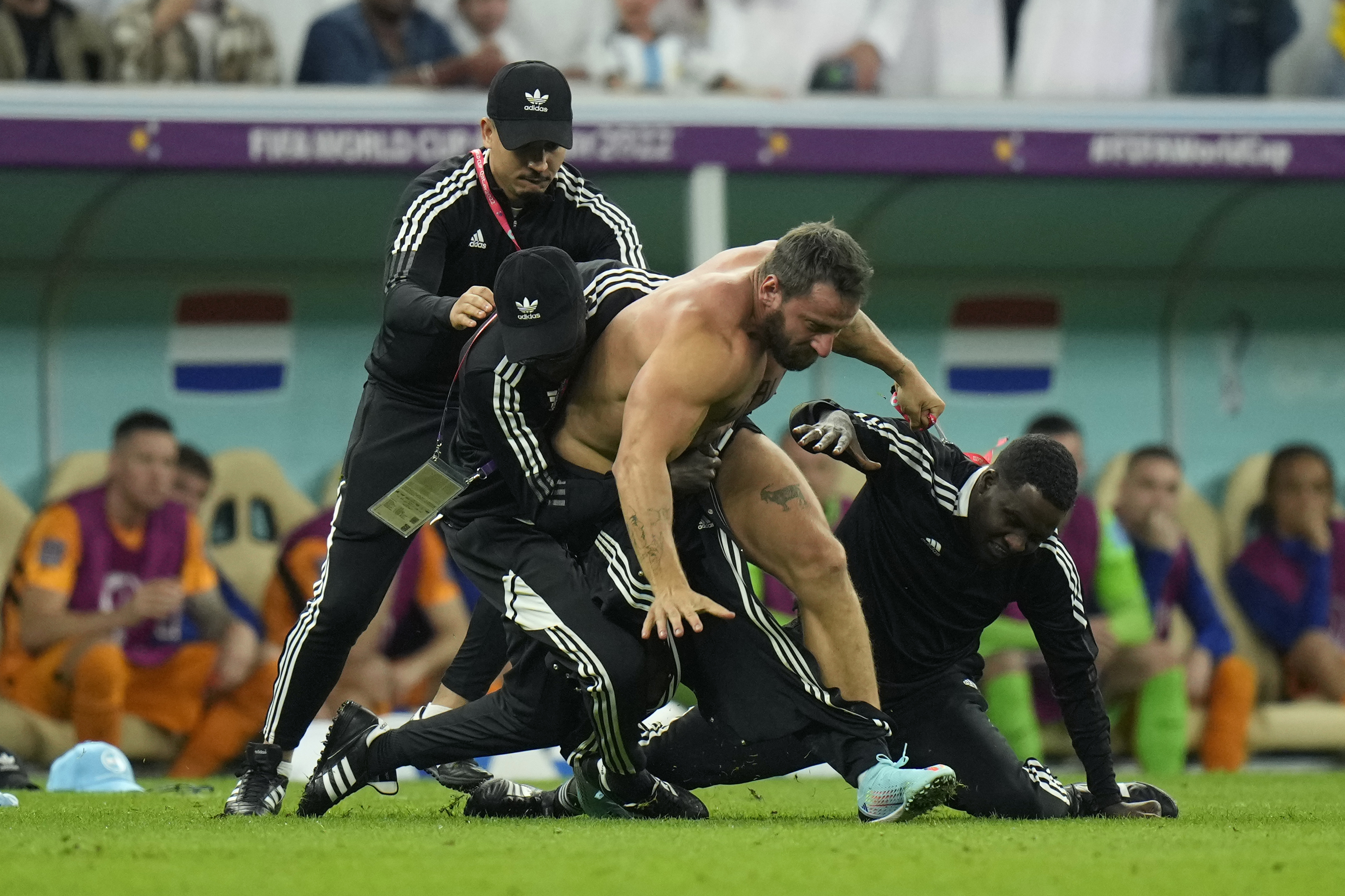 A pitch invader is tackled by security during the World Cup quarterfinal soccer match between the Netherlands and Argentina, at the Lusail Stadium in Lusail, Qatar, Friday, Dec. 9, 2022.