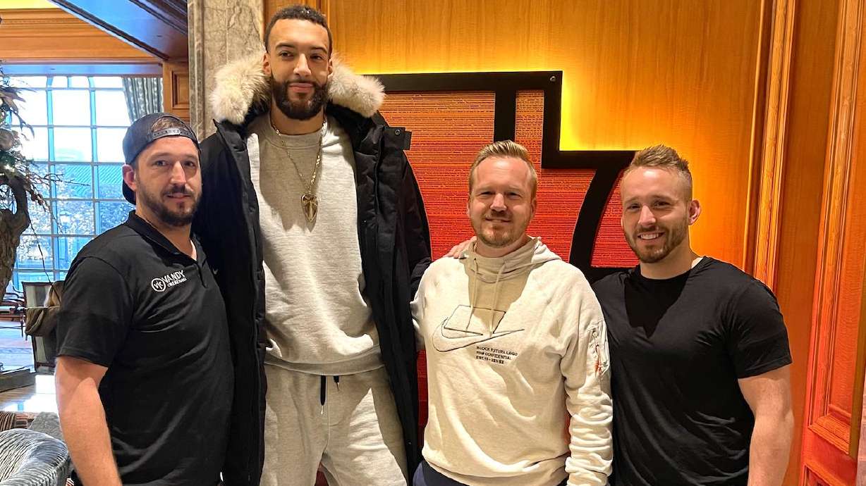 Rudy Gobert stands with the owners of Vandy Creations after they surprised with a thank you sign.