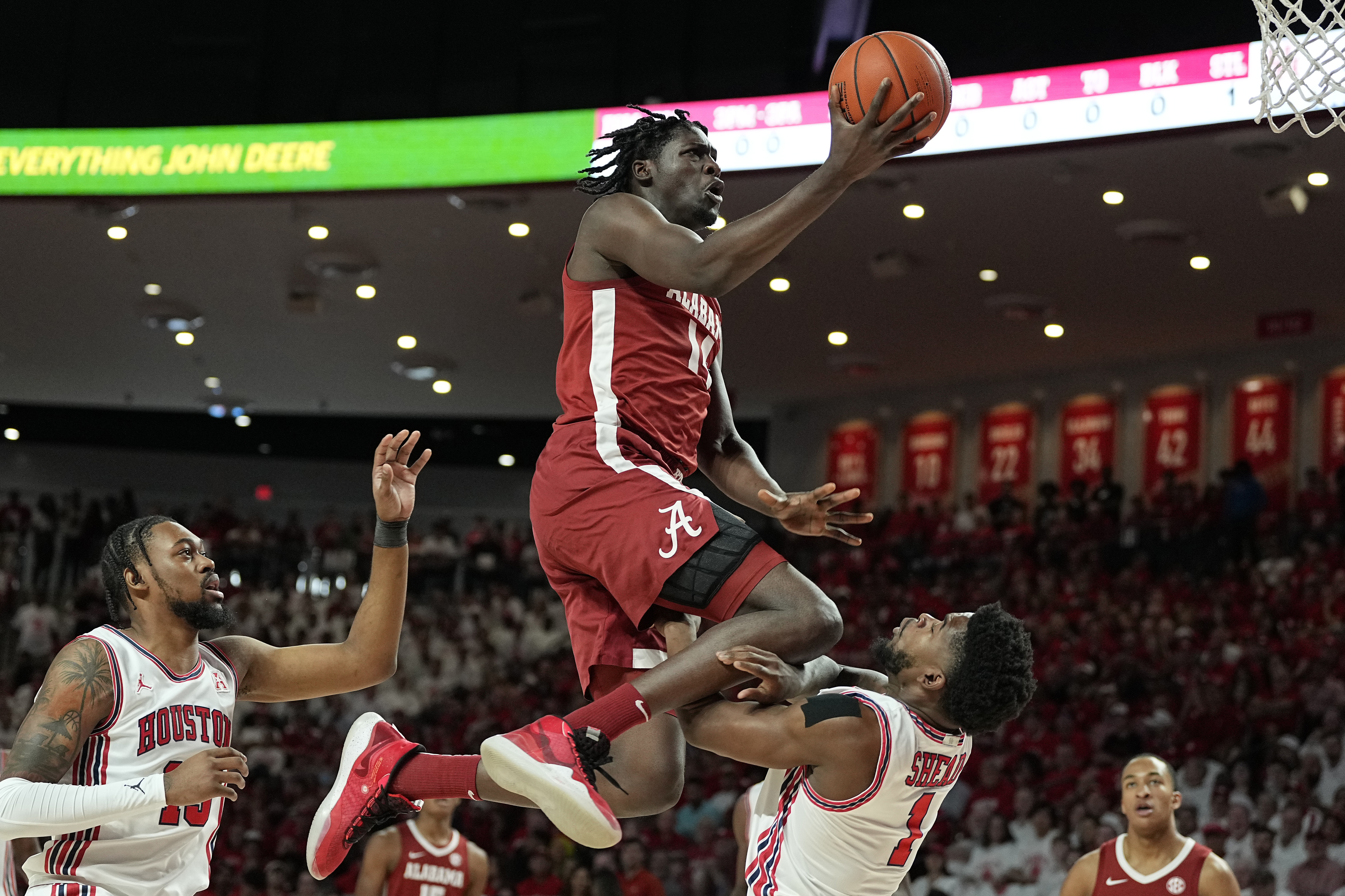 Alabama center Charles Bediako (14) is fouled by Houston guard Jamal Shead (1), right, during the first half of an NCAA college basketball game, Saturday, Dec. 10, 2022, in Houston. 
