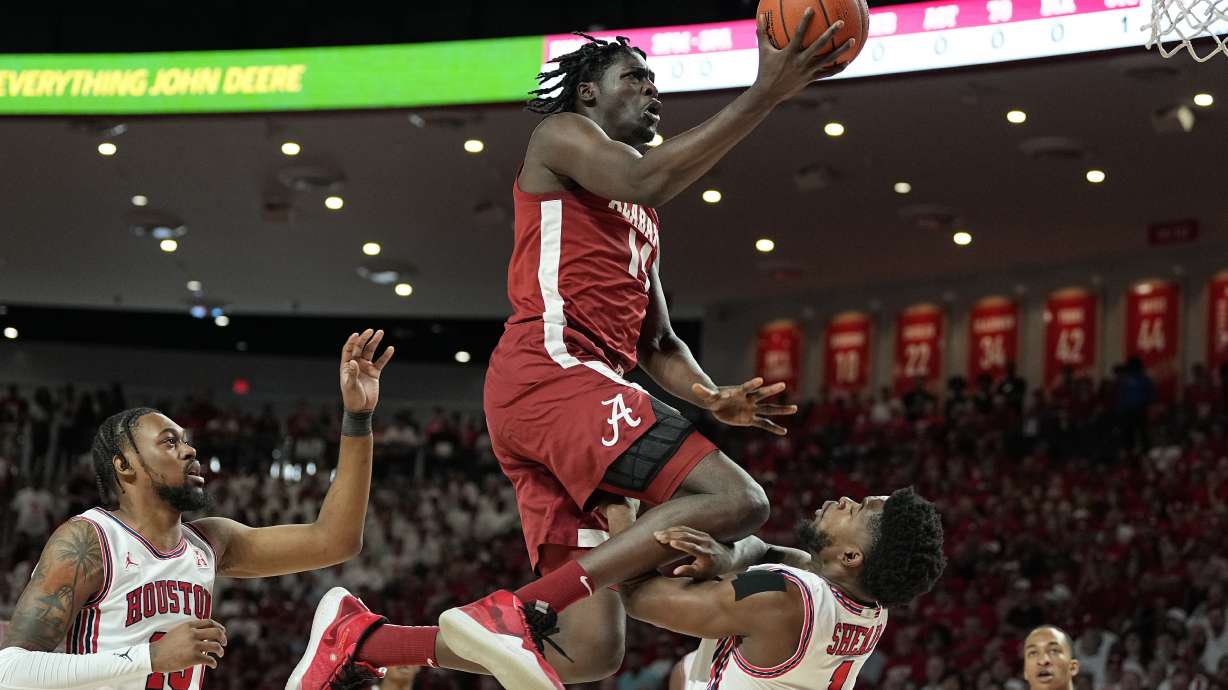 Alabama center Charles Bediako (14) is fouled by Houston guard Jamal Shead (1), right, during the first half of an NCAA college basketball game, Saturday, Dec. 10, 2022, in Houston.