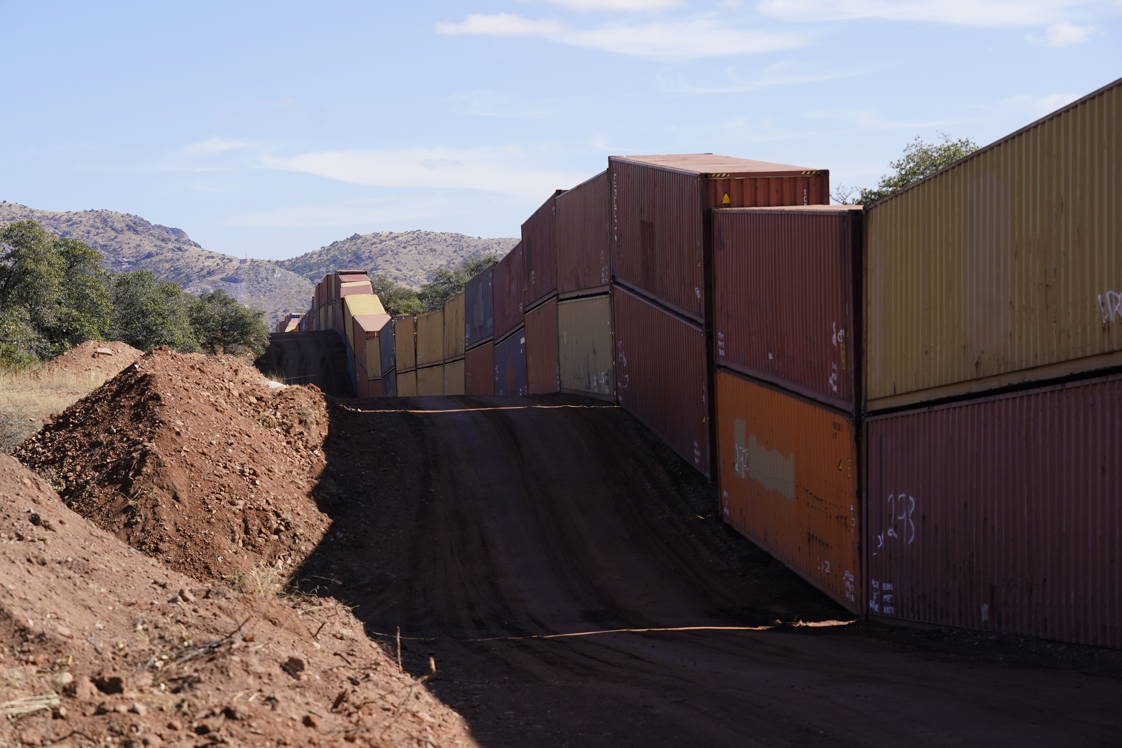 A long row of double-stacked shipping containers provide a new wall between the United States and Mexico in the remote section area of San Rafael Valley, Arizona, Dec. 8. Republican Gov. Doug Ducey made a bold show of border enforcement even as he prepares to step aside next month for Democratic Governor-elect Katie Hobbs. 