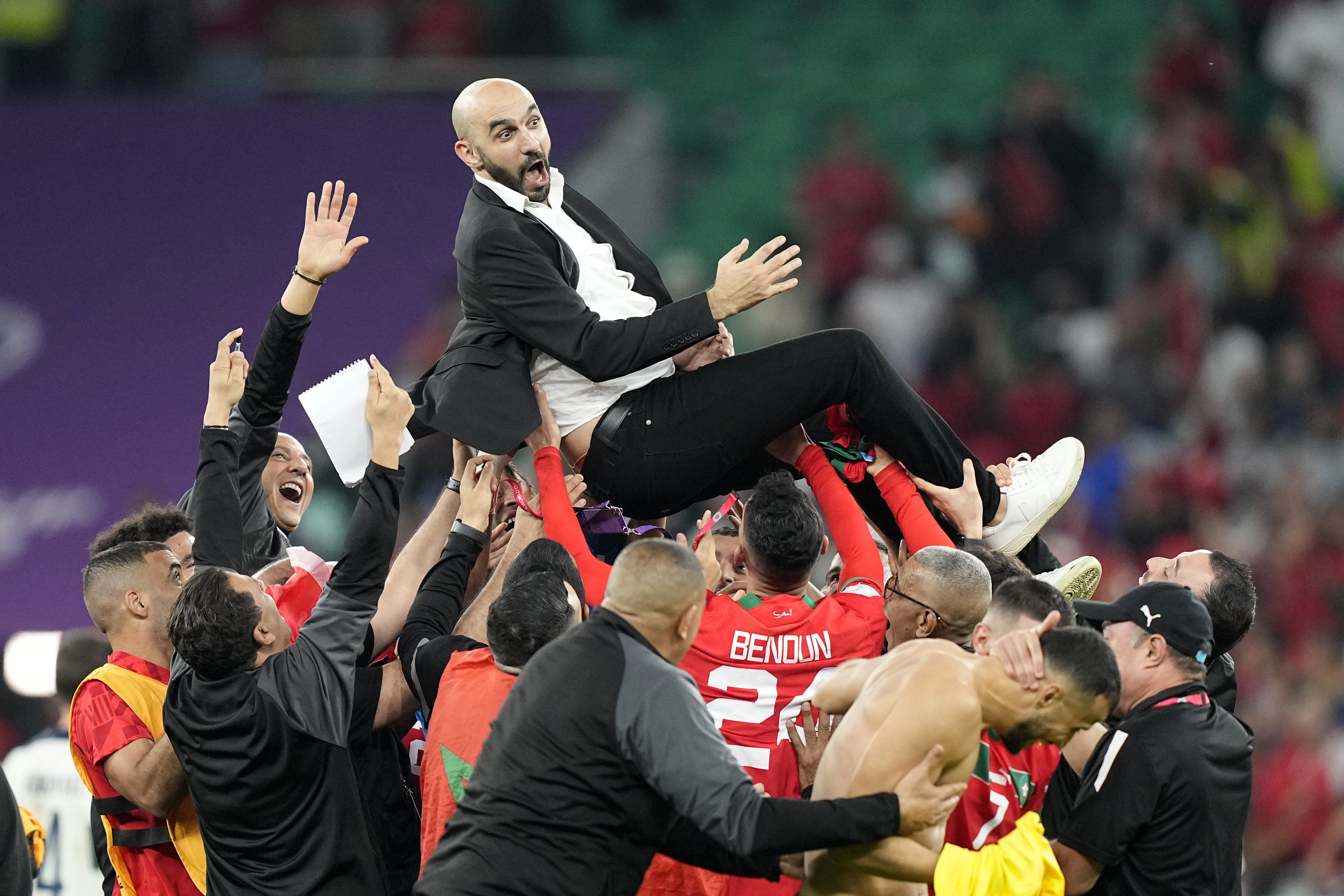Morocco's head coach Walid Regragui is thrown in the air by players after the World Cup quarterfinal soccer match between Morocco and Portugal, at Al Thumama Stadium in Doha, Qatar, Saturday, Dec. 10, 2022.