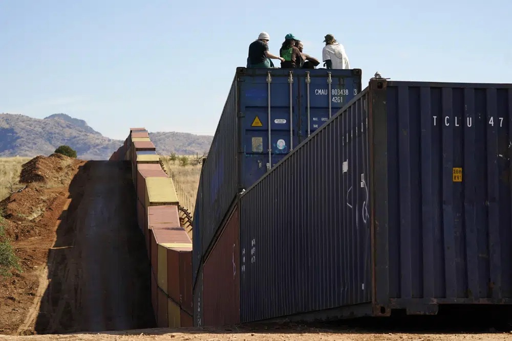 Activists sit on newly installed shipping containers along the border creating a wall between the United States and Mexico in San Rafael Valley, Arizona, Dec. 8.