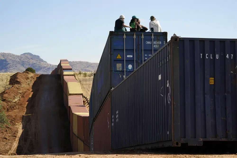 Activists sit on newly installed shipping containers along the border creating a wall between the United States and Mexico in San Rafael Valley, Arizona, Dec. 8.