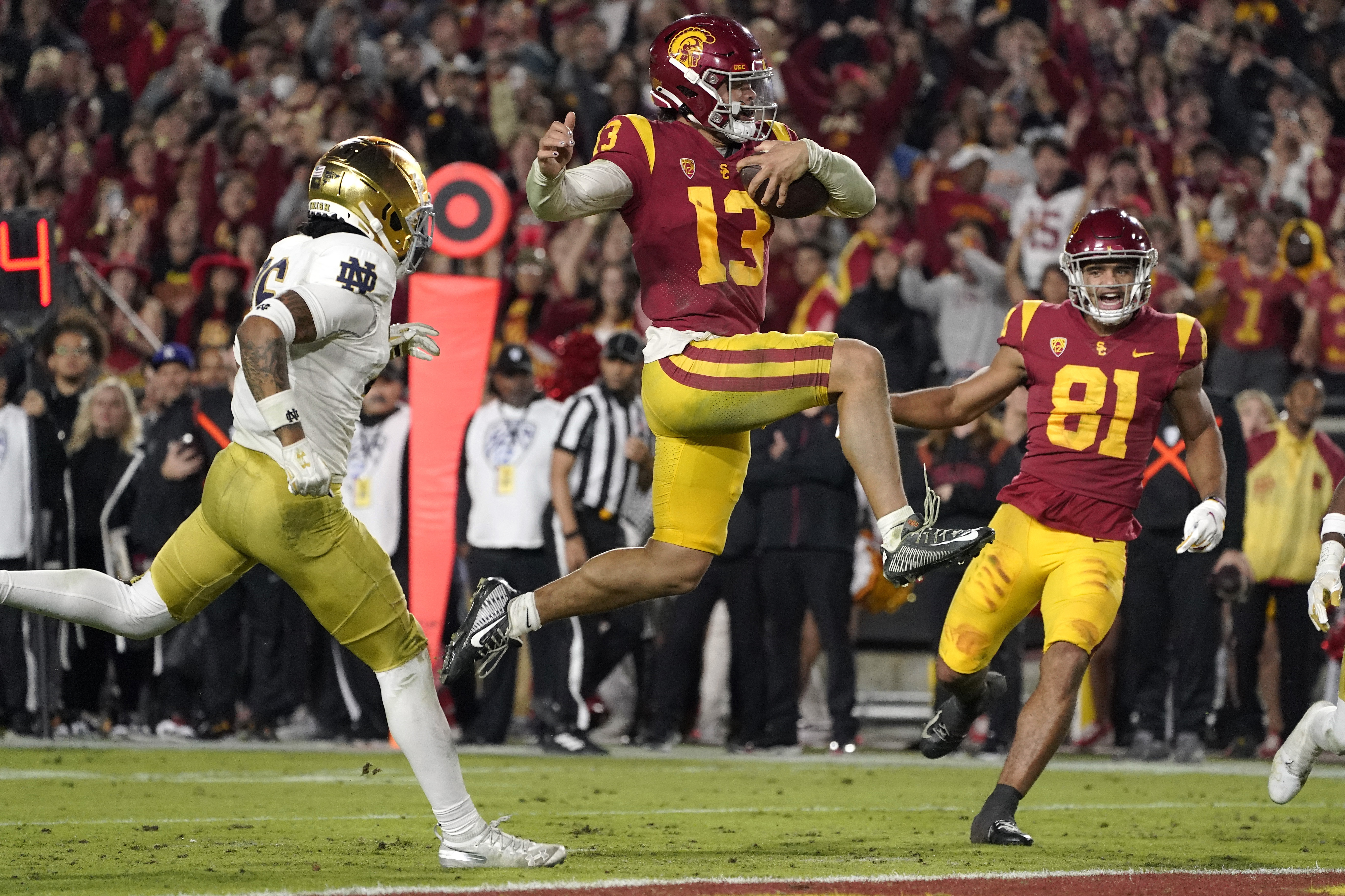 FILE - Southern California quarterback Caleb Williams jumps in for a touchdown as Notre Dame safety Xavier Watts, left, defends and Southern California wide receiver Kyle Ford watches during the second half of an NCAA college football game Saturday, Nov. 26, 2022, in Los Angeles. Southern California quarterback Caleb Williams was named the AP Player of the Year in college football, Thursday, Dec. 8, 2022.
