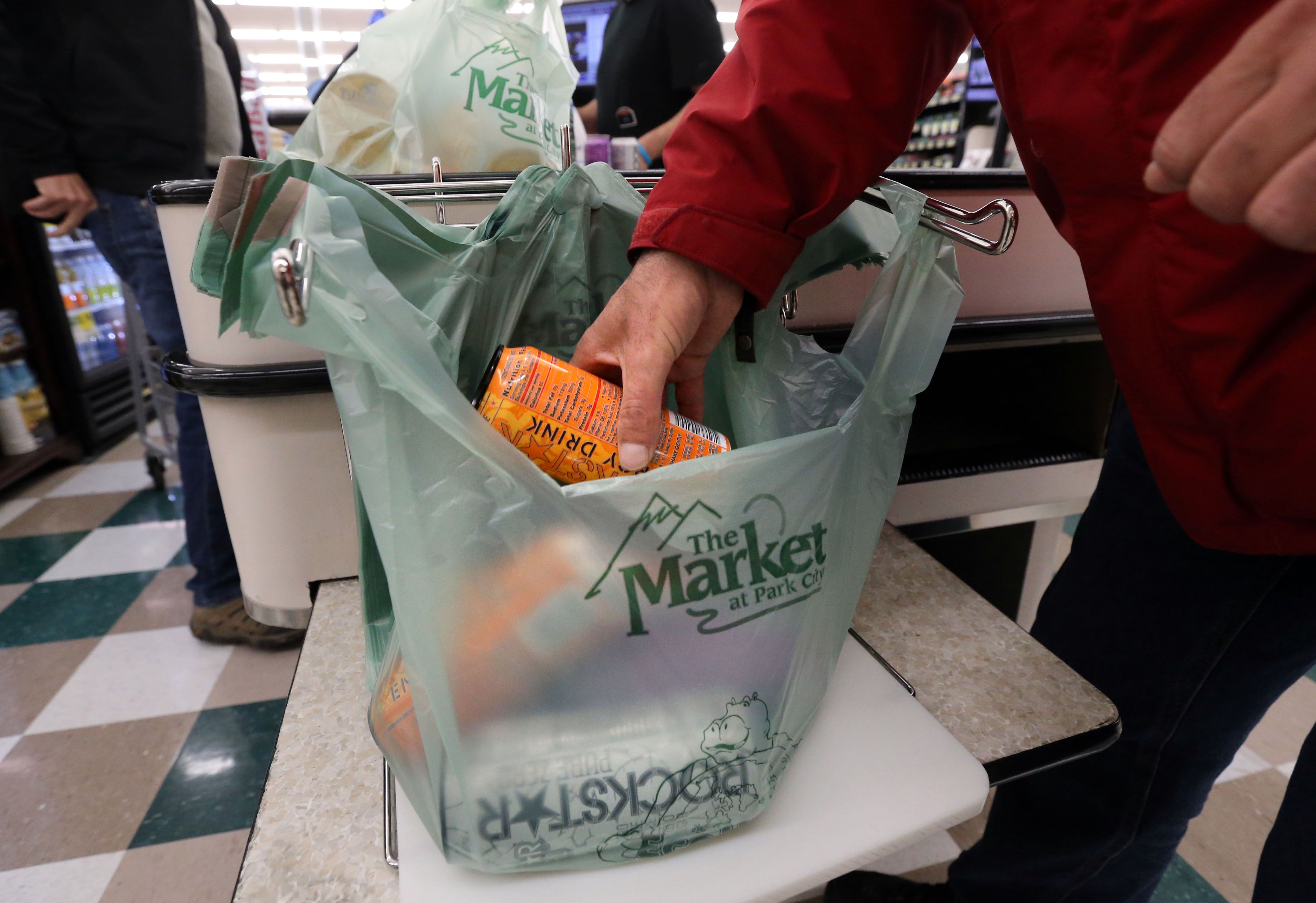 Riley War bags groceries at The Market at Park City in Park City on May 16, 2017. The state of Colorado will impose a 10-cent charge to use plastic or paper bags at stores beginning in 2023.