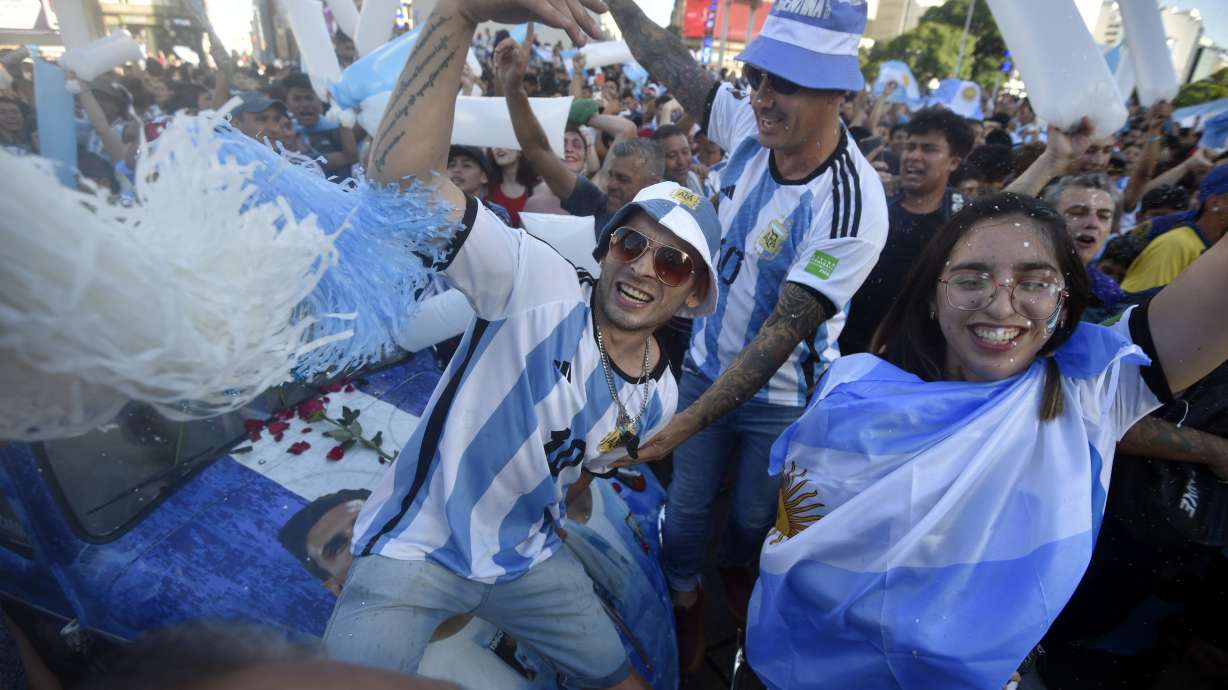 Argentina soccer fans celebrate their team's victory over Croatia at the end of the team's World Cup semifinal match in Qatar after watching it on TV in Buenos Aires, Argentina, Tuesday, Dec. 13, 2022.