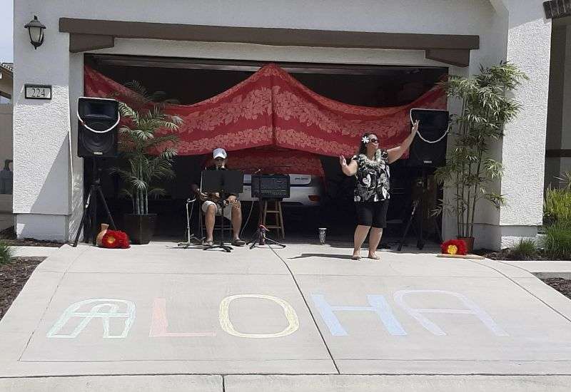 Lisa and Larry Neula perform Hawaiian dance and music for neighbors in Sacramento, Calif., in April 2020.
