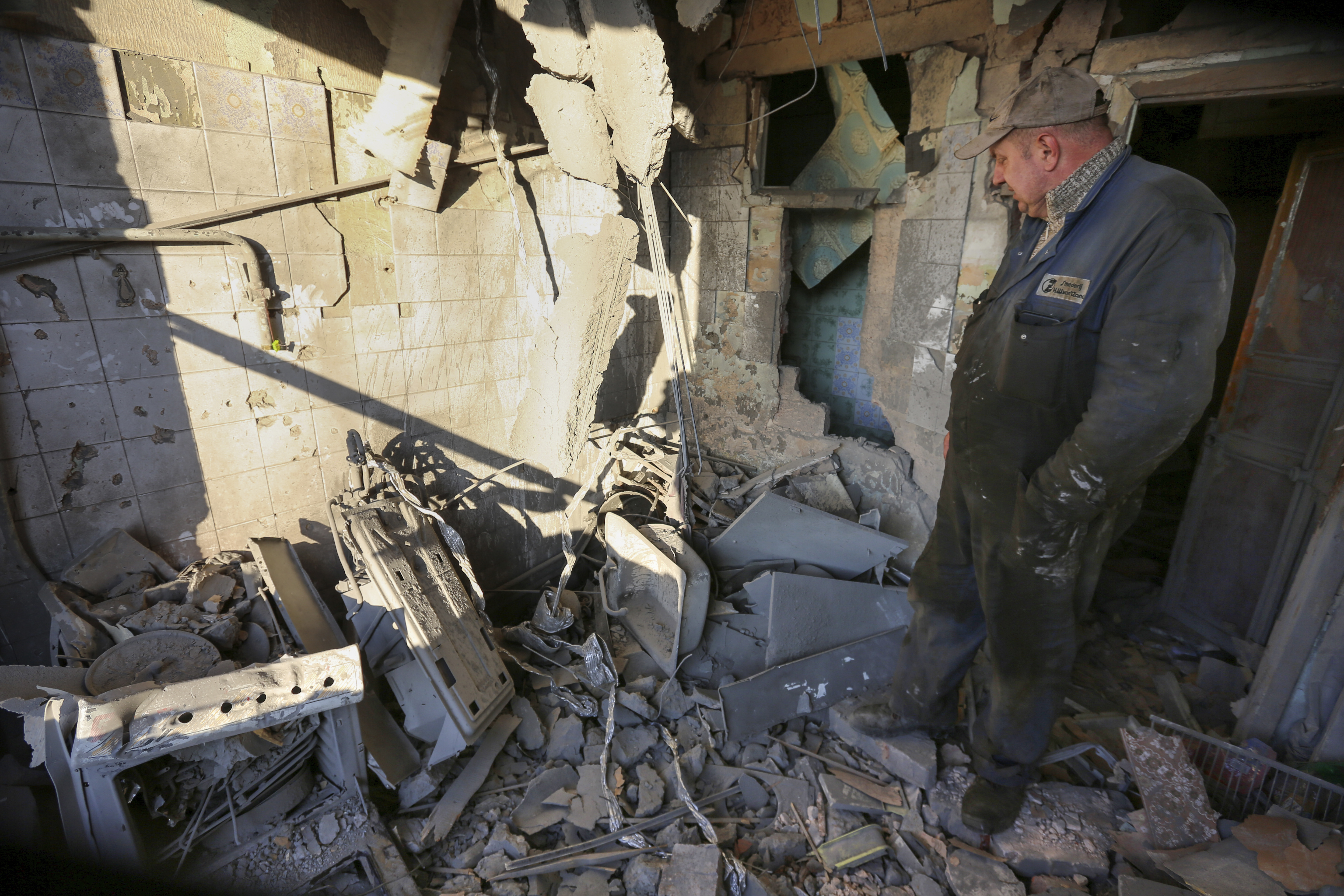 A man examines a damaged building after what Russian officials called a shelling by Ukrainian forces in Donetsk, eastern Ukraine, Thursday. 