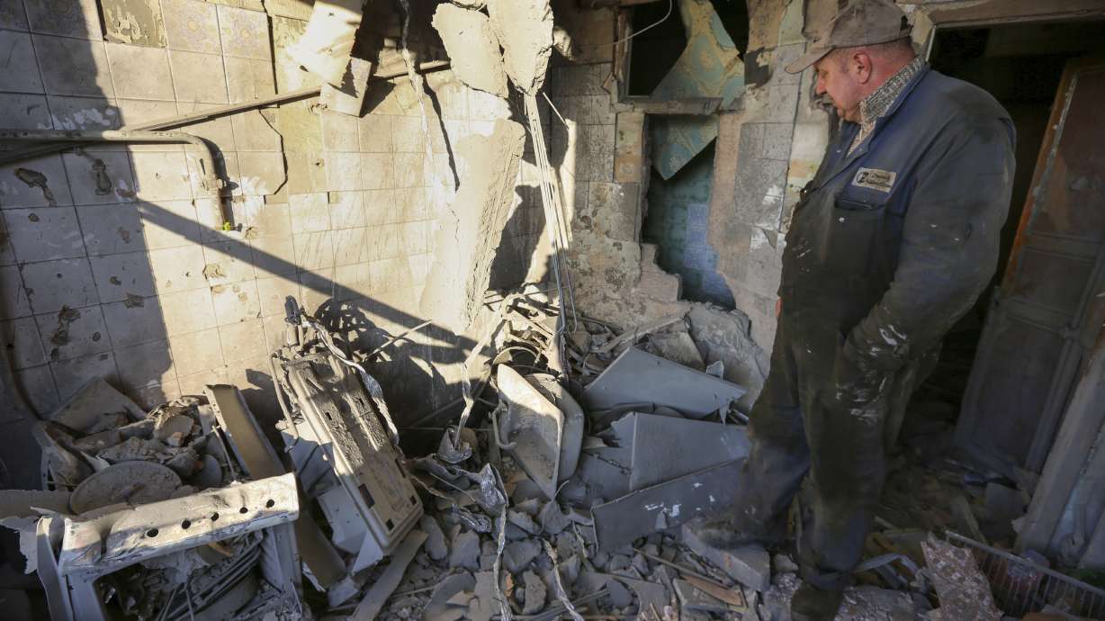 A man examines a damaged building after what Russian officials called a shelling by Ukrainian forces in Donetsk, eastern Ukraine, Thursday.