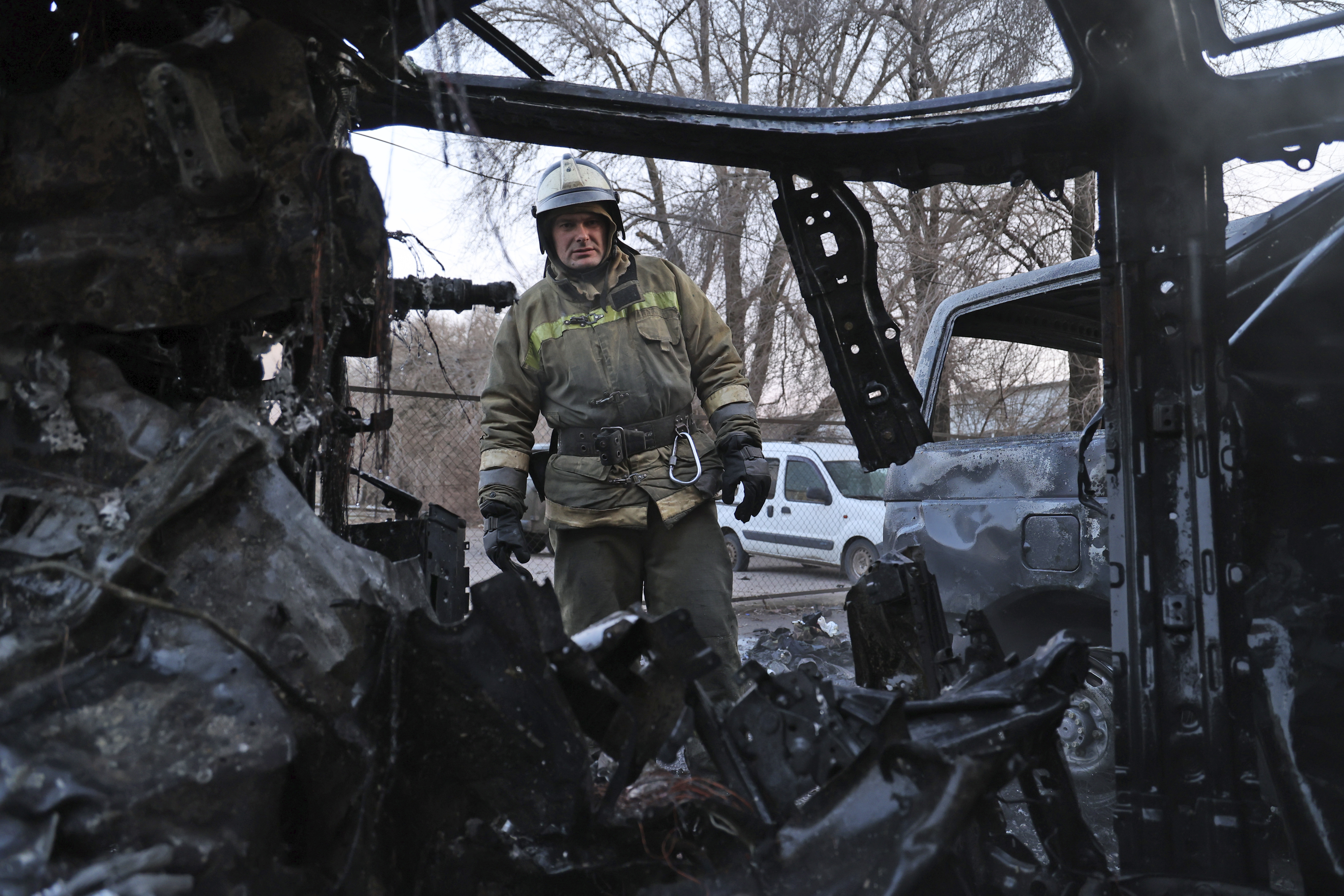 A firefighter examines a burned car after what Russian officials in Donetsk said was a shelling by Ukrainian forces, in Donetsk, eastern Ukraine, Thursday.