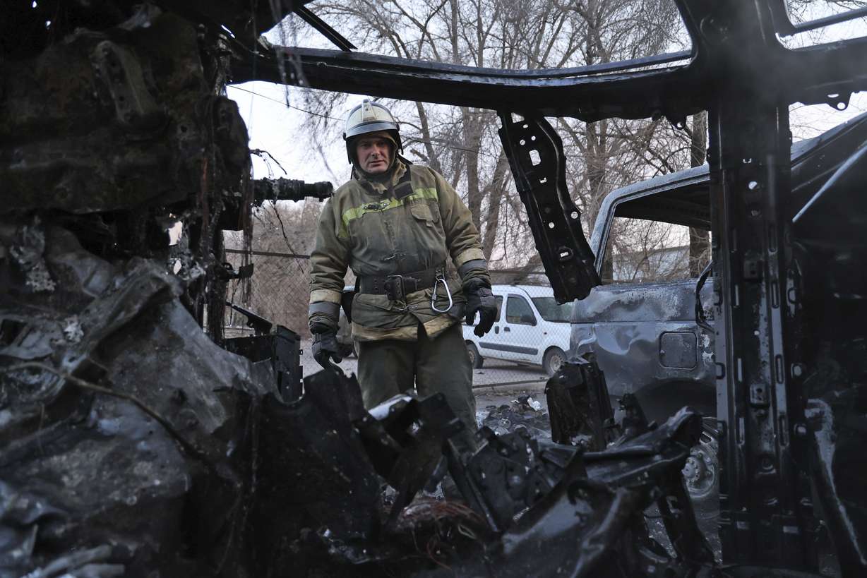 A firefighter examines a burned car after what Russian officials in Donetsk said was a shelling by Ukrainian forces, in Donetsk, eastern Ukraine, Thursday.