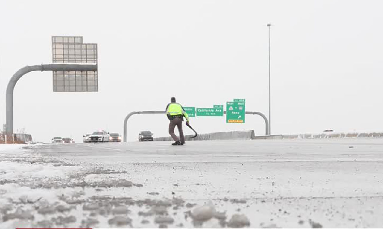 A UHP trooper retrieves debris Wednesday.