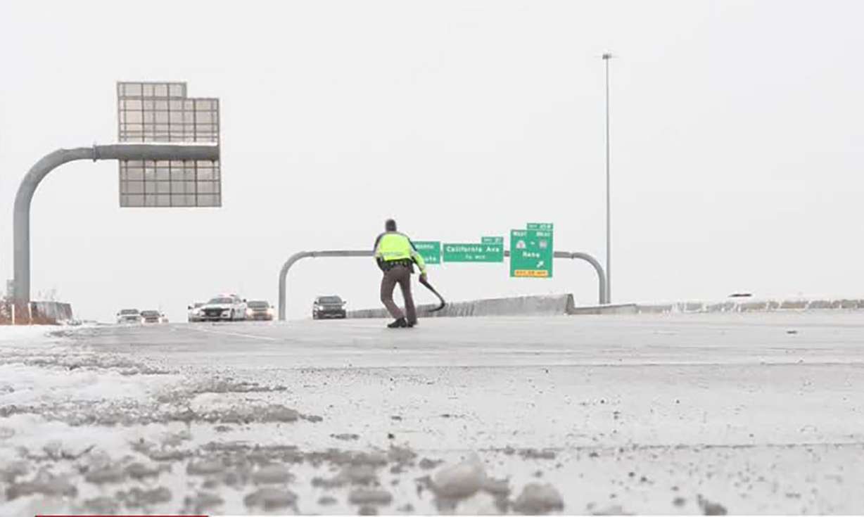 A UHP trooper retrieves debris Wednesday.