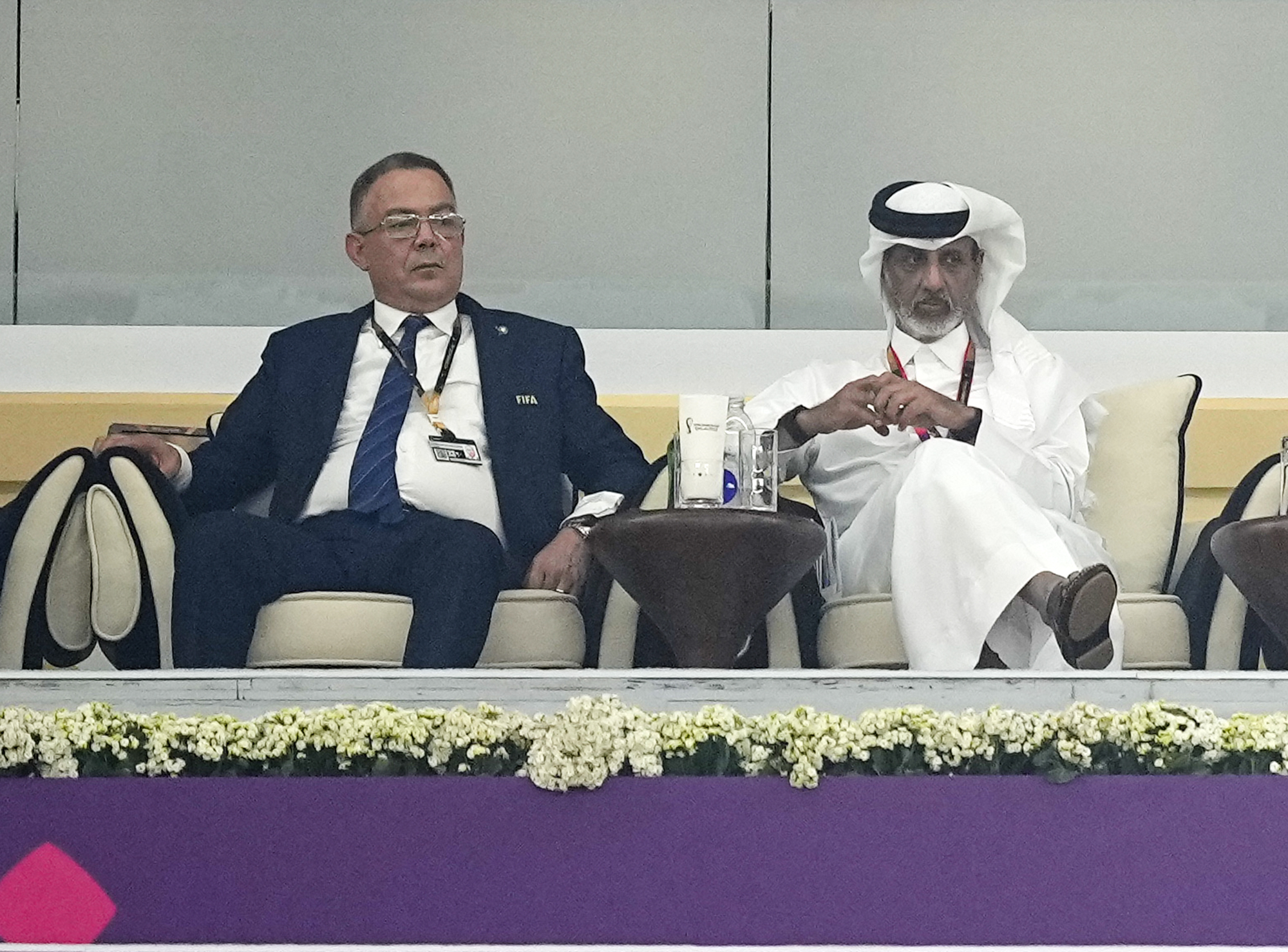 Moroccan FA President Fouzi Lekjaa, left, sits in the tribune for the World Cup semifinal soccer match between France and Morocco at the Al Bayt Stadium in Al Khor, Qatar, Wednesday, Dec. 14, 2022.